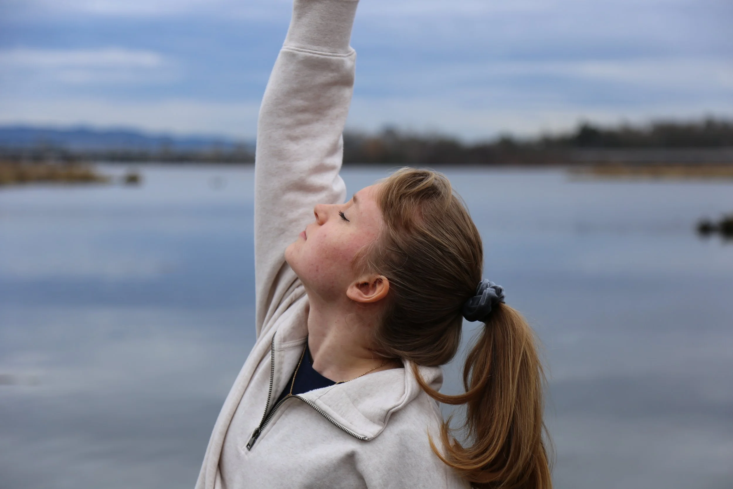 A young woman practicing yoga outside on the University of Washington Wetlands.