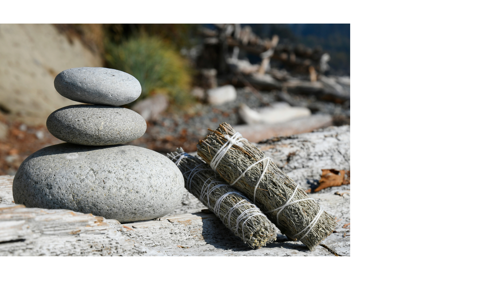 Stacked stones and sage bundles representing mindfulness and intentional home organizing