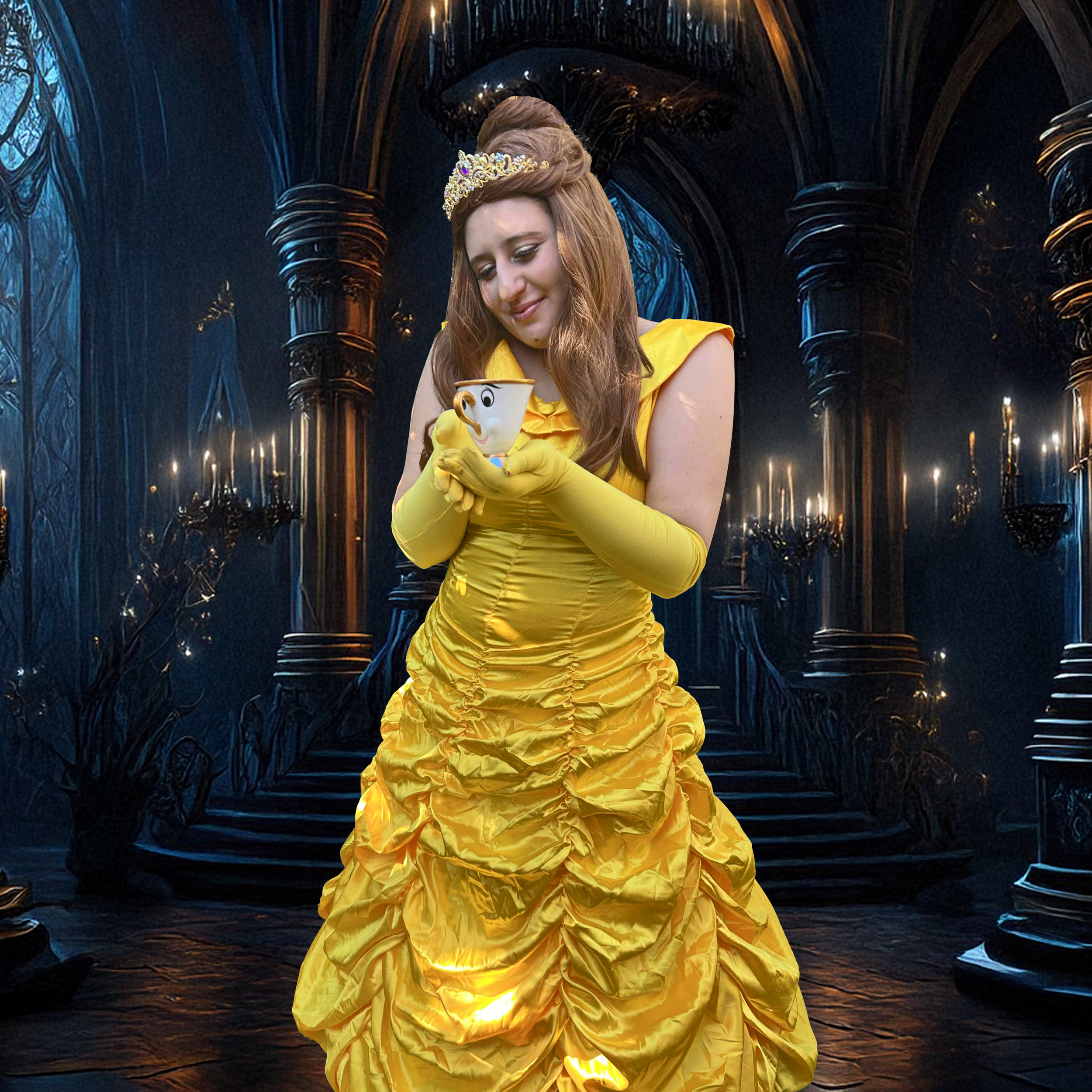 A woman dressed as Belle in a yellow ball gown from Beauty and the Beast, holding Chip the teacup with a face and smiling in a dark, gothic, magical castle setting.