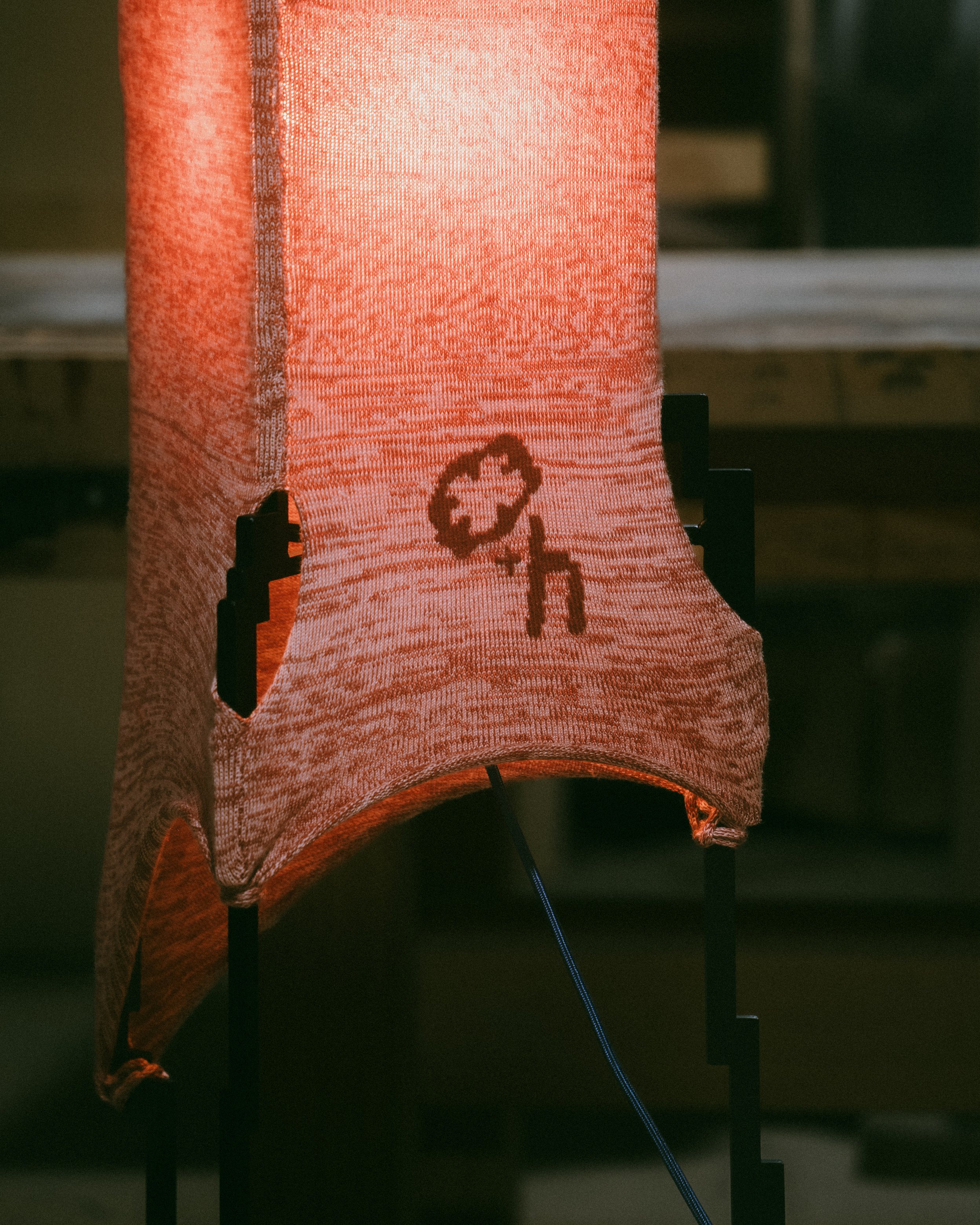 Glitch lamp detail showing knitwear glitch effect across pixelated lamp frame design