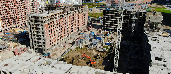 Interior of a modern restaurant with tables, chairs, and booth seating, brick walls, large windows, and contemporary lighting fixtures.