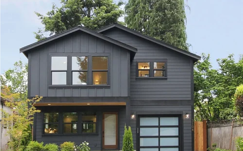 Modern kitchen with white cabinets, black hardware, stainless steel appliances, and light wood flooring, featuring a loft area with a wooden ladder.