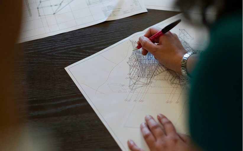 Interior of a modern restaurant with tables, chairs, and booth seating, brick walls, large windows, and contemporary lighting fixtures.