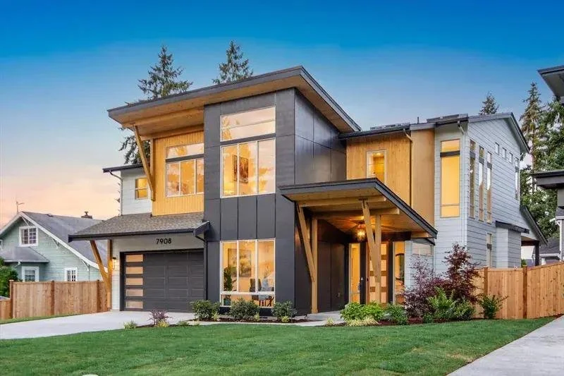 Modern kitchen with white cabinets, black hardware, stainless steel appliances, and light wood flooring, featuring a loft area with a wooden ladder.