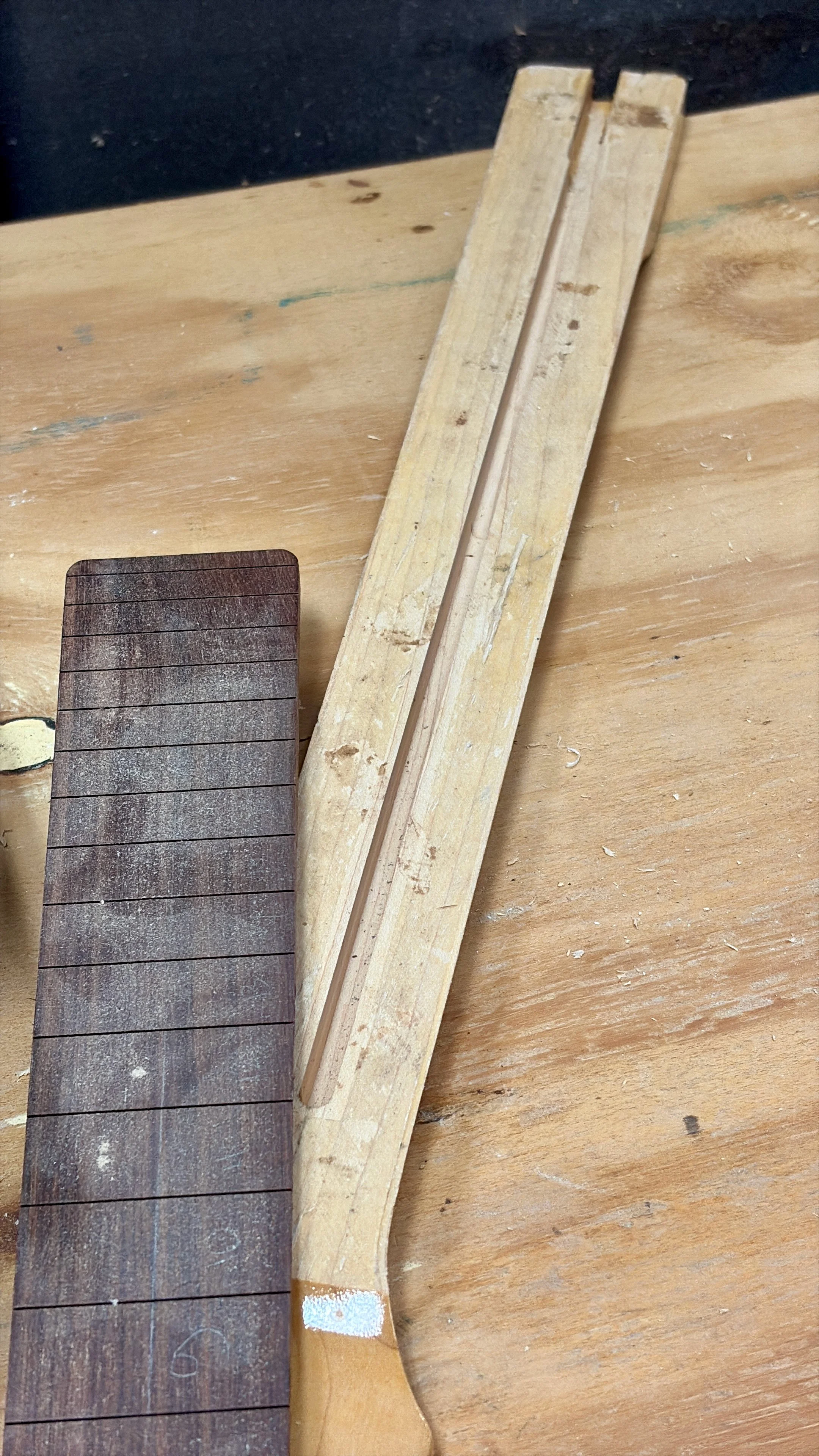 Een stuk hout met een gekerfd markering en een stuk hout dat wordt gebruikt bij houtbewerking op een werkbank.