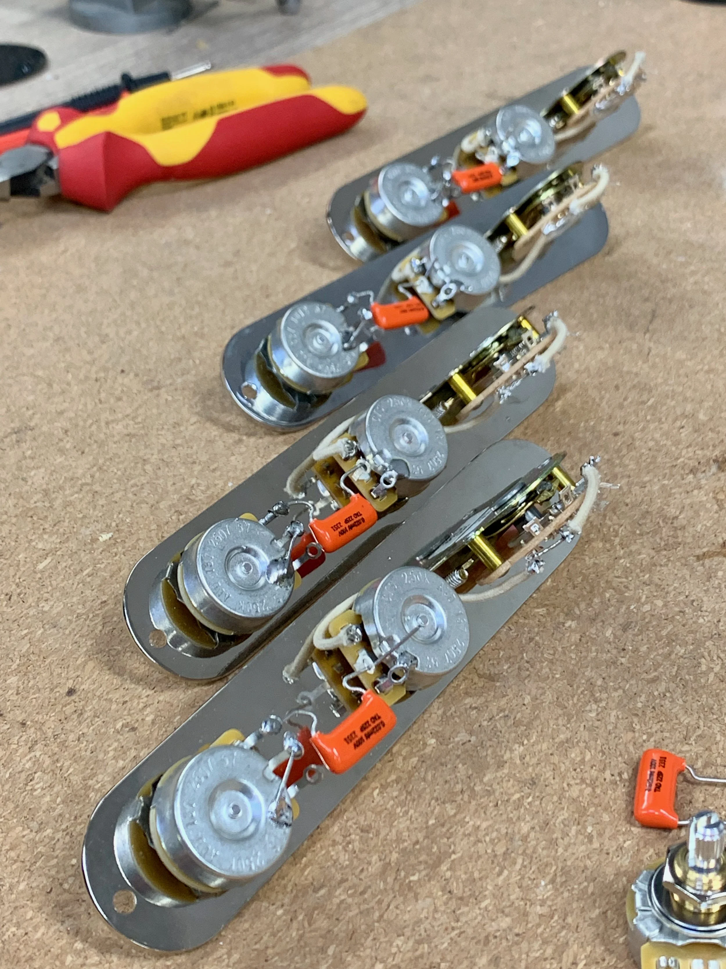 Elektronische schakeling met meerdere condensatoren en draden op een werkblad.