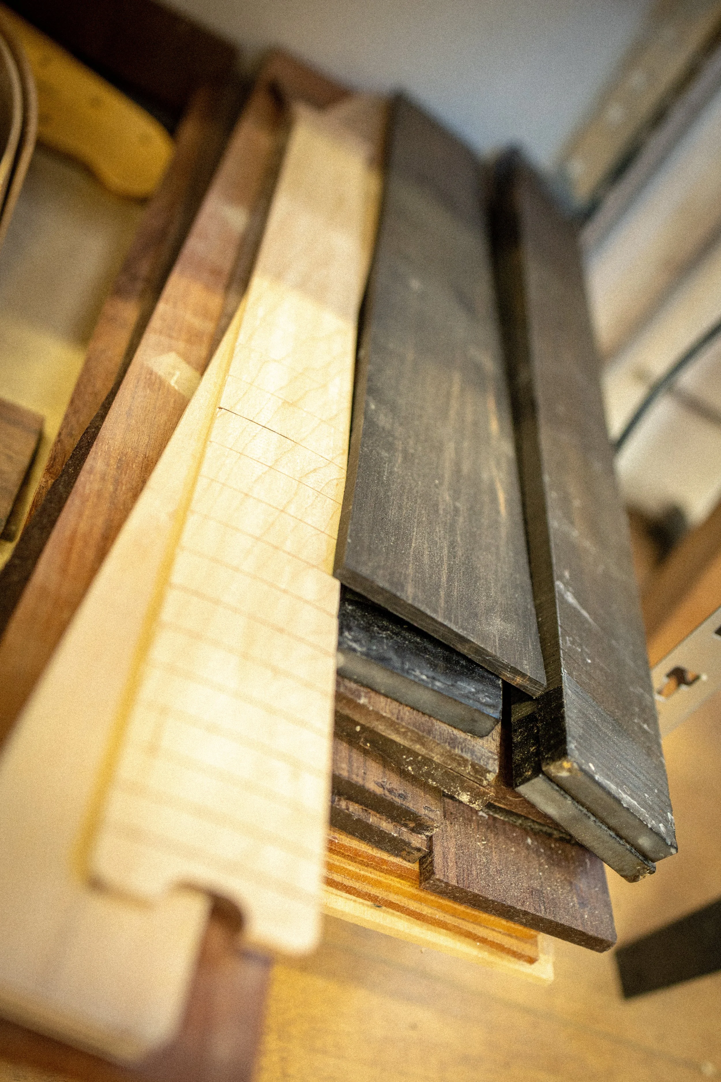 Verschillende houten blokken gestapeld, variërend in kleur en formaat.