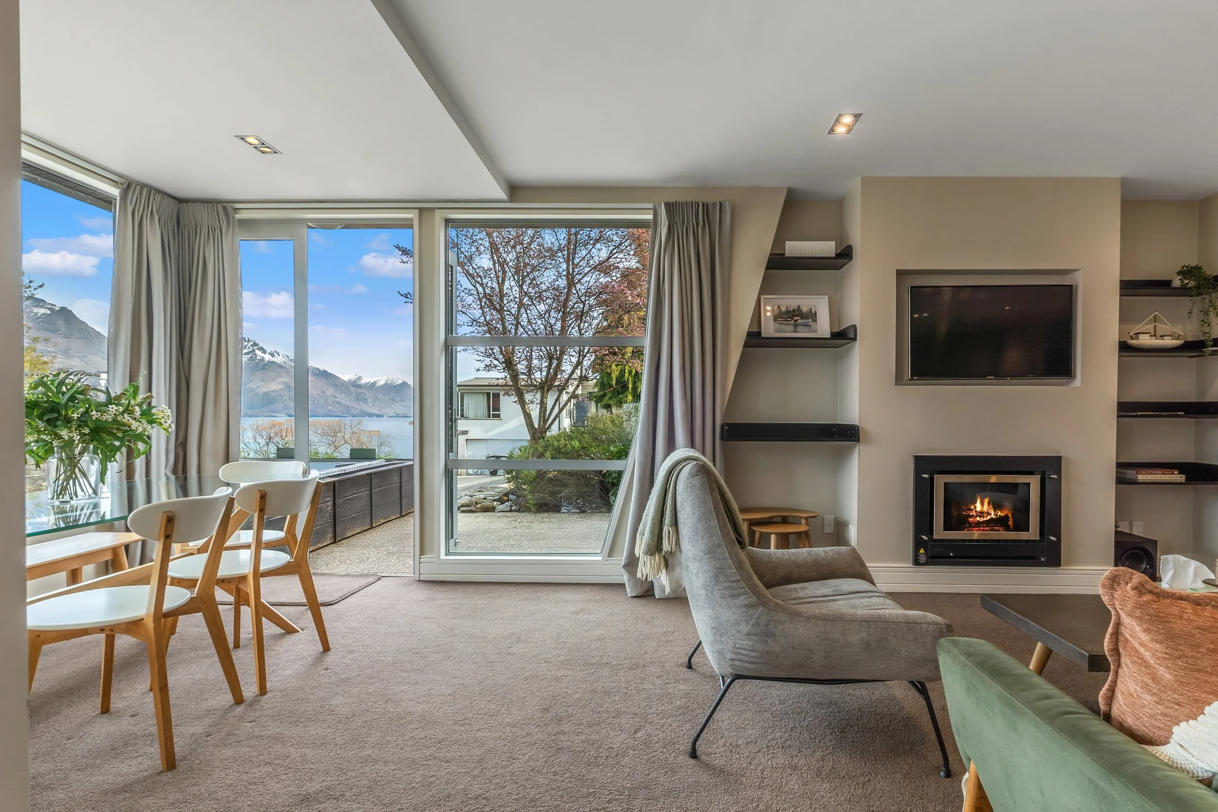 Queenstown apartment living area with a fireplace and lake and mountain views, managed by Lake & Peak Property Management