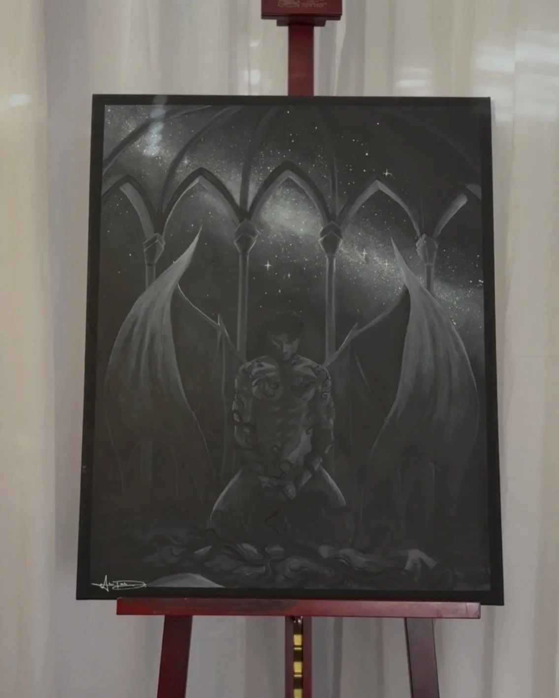 Exposed winged man kneeling below sky of stars