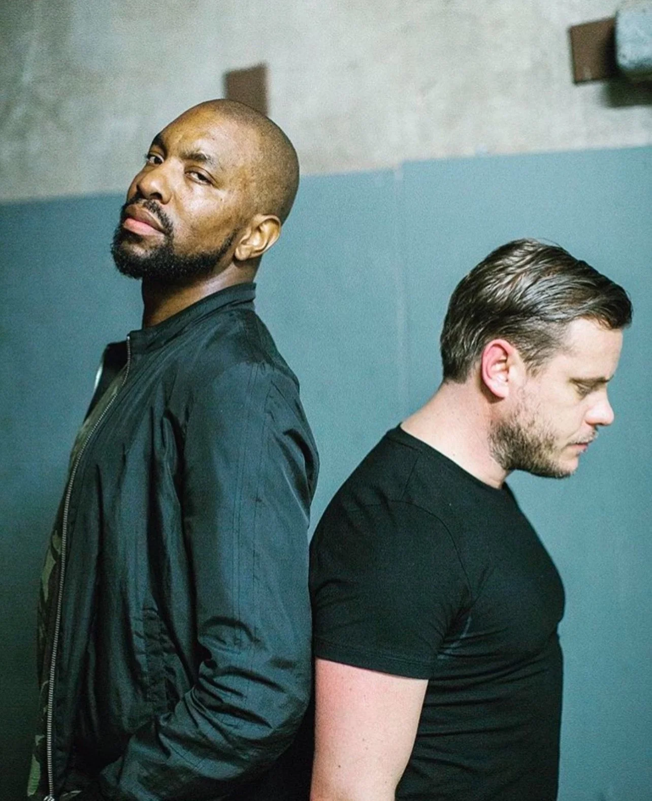 Artful Dodger duo during a stylish promotional photo shoot, iconic UK garage producers behind hits like “Re-Rewind” featuring Craig David, pioneers of 90s and 2000s dance music.