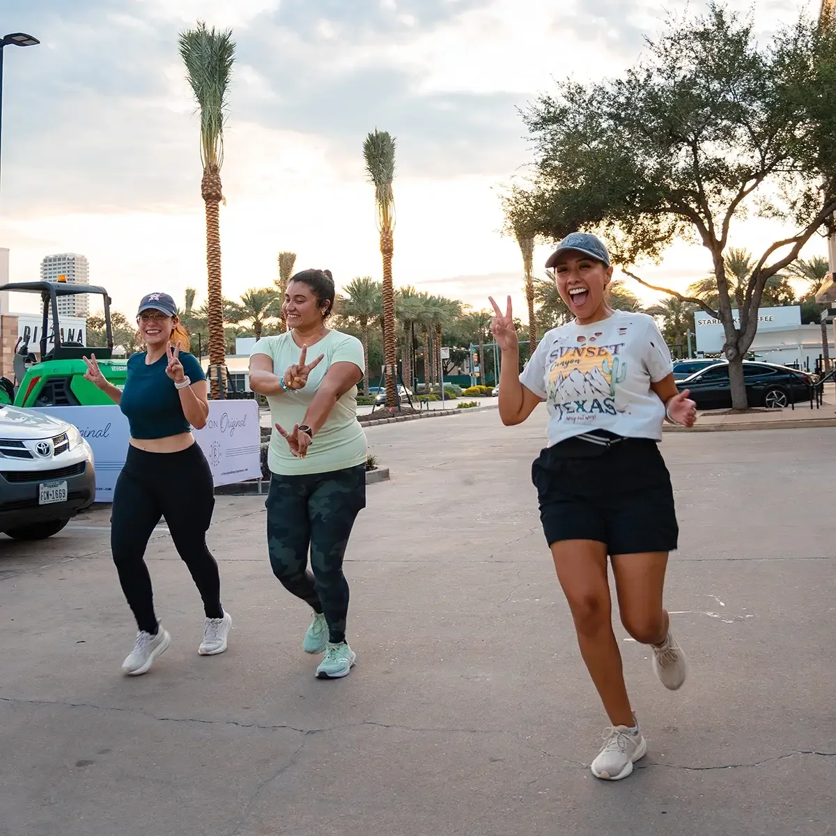 A group of girls running at a photoshoot event posing towards a photographer in Houston.