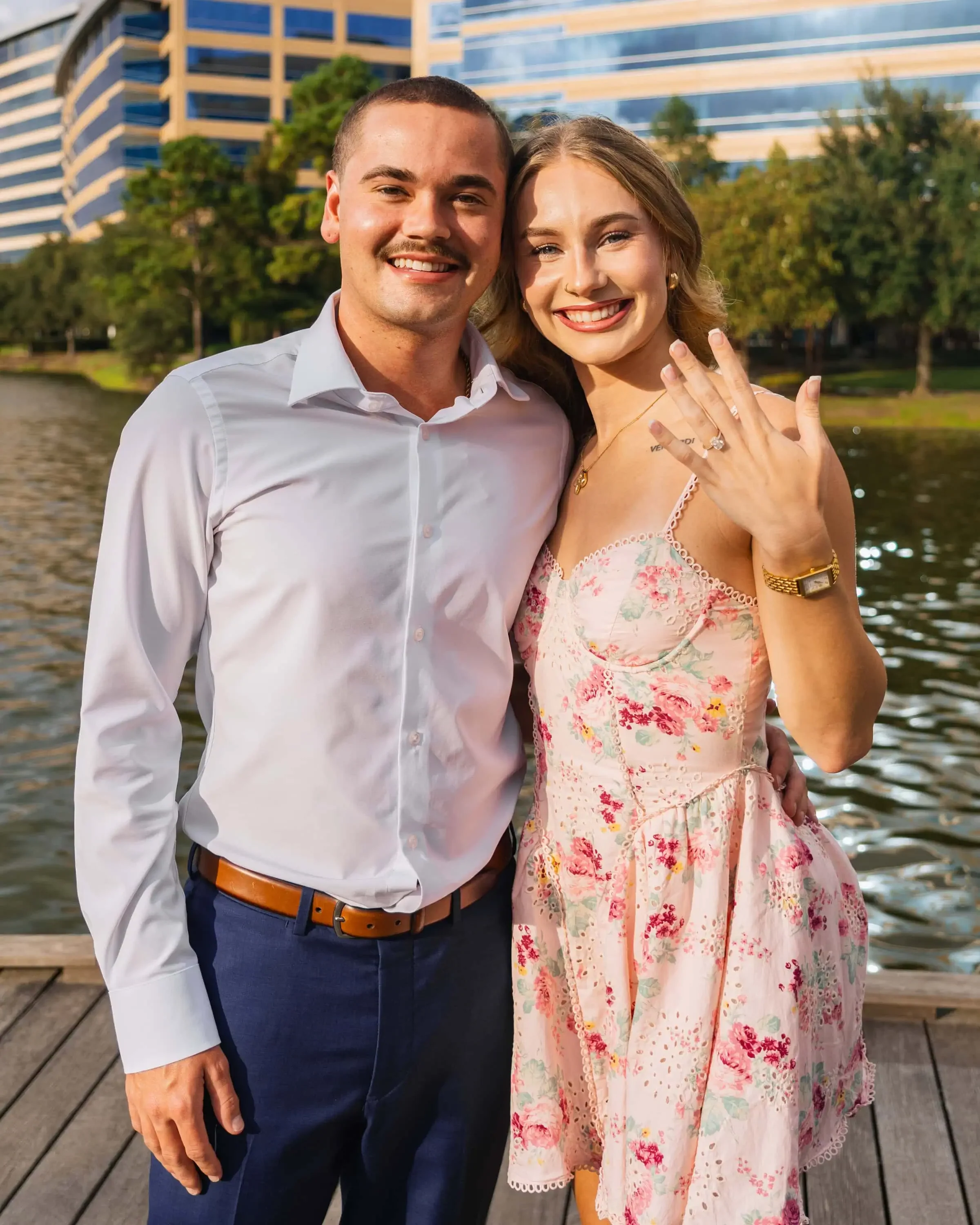 An newly engaged couple posing together with for an engagement photographer to capture their shot.