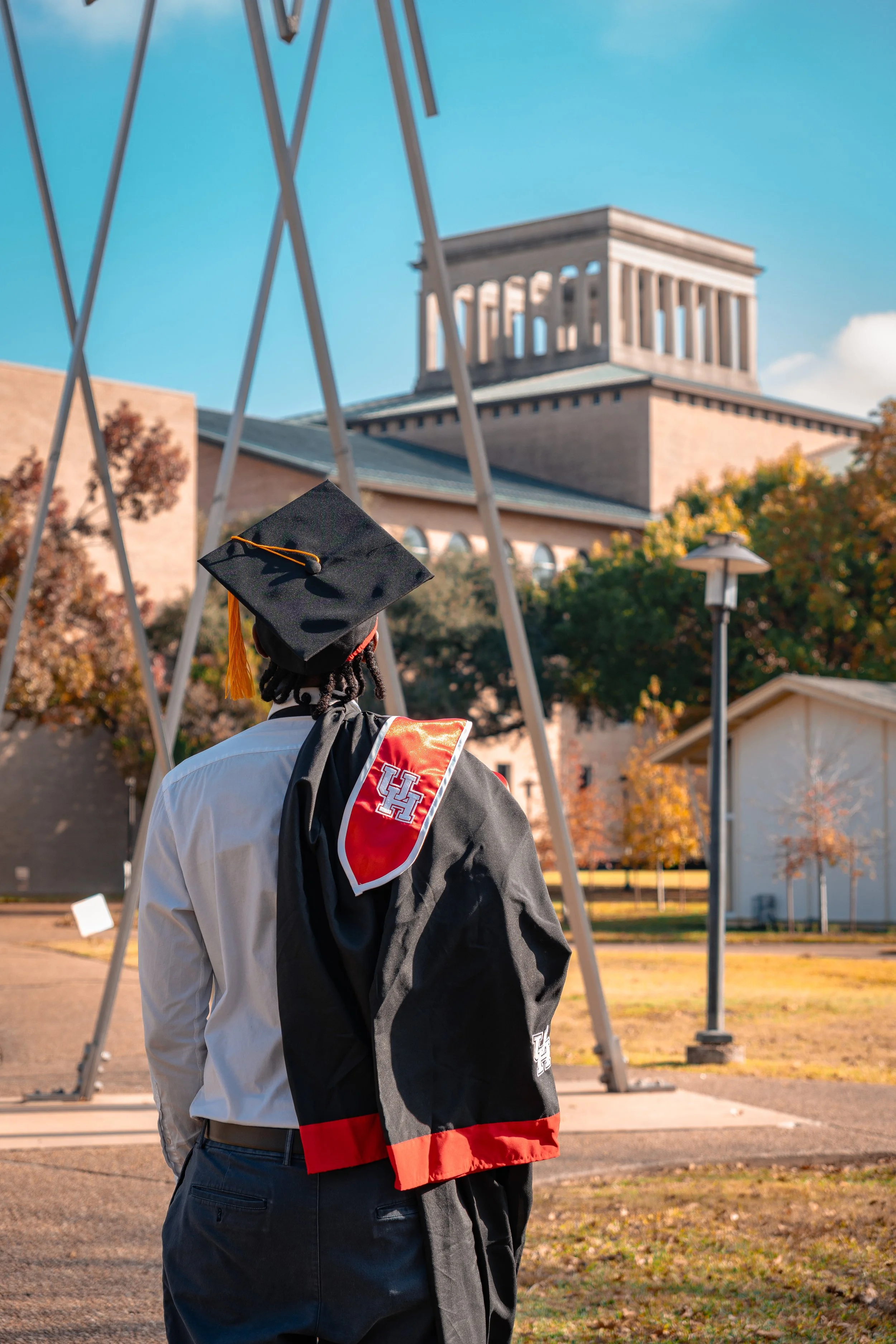 A U of H graduate getting a nice photo from behind by a photographer for graduation.