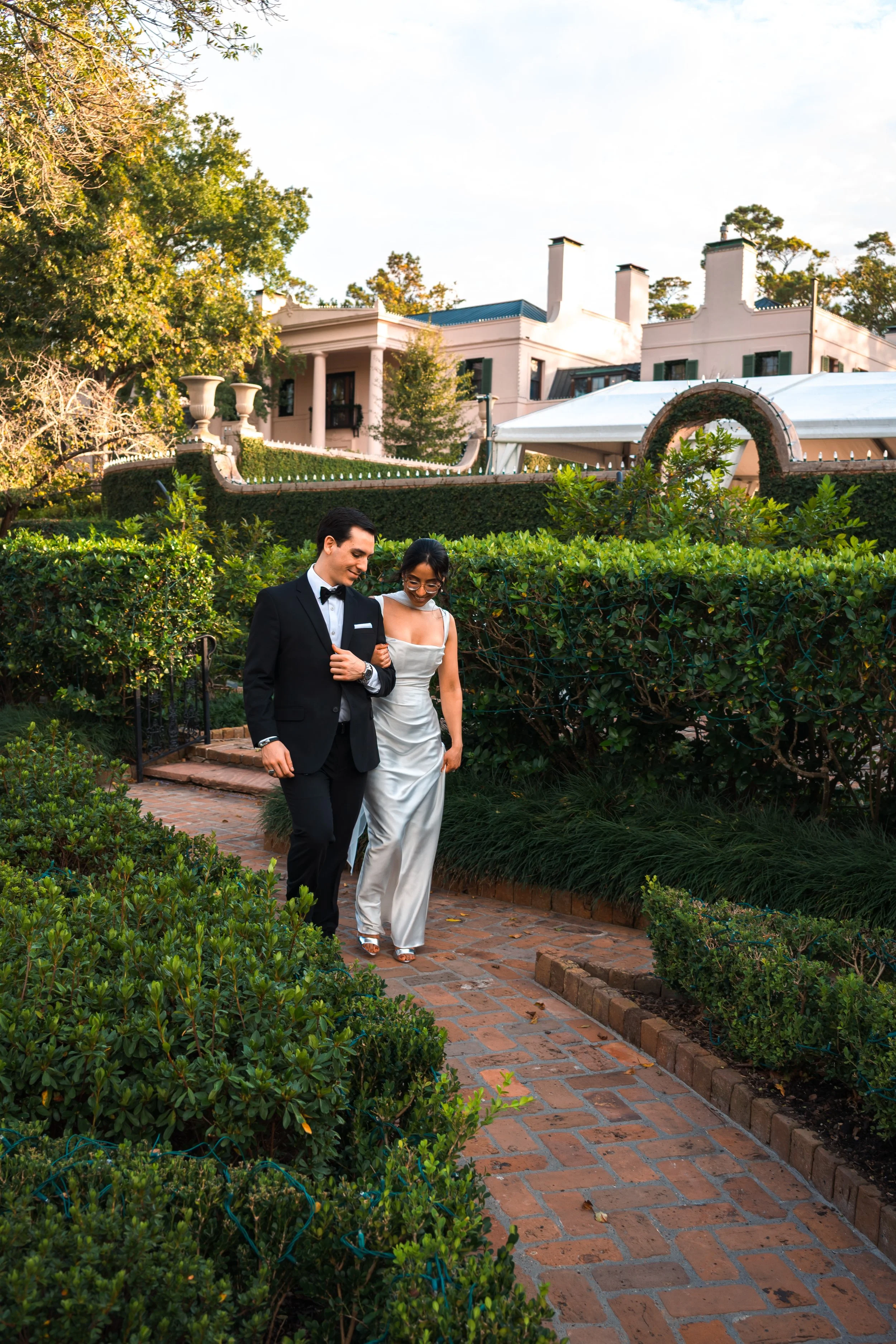 An newly engaged couple walking through a garden in Houston during their photoshoot with a engagement proposal photographer.