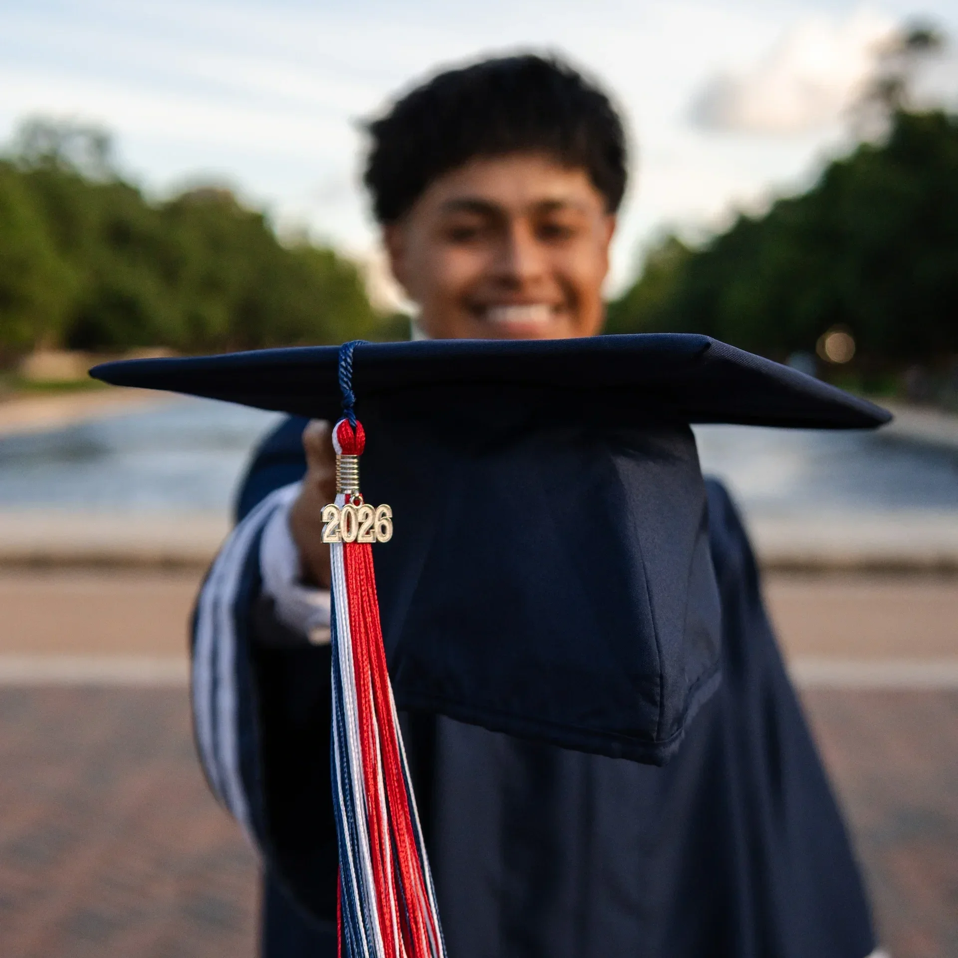 A high school student holding his blue cap for his graduation photoshoot in Houston.