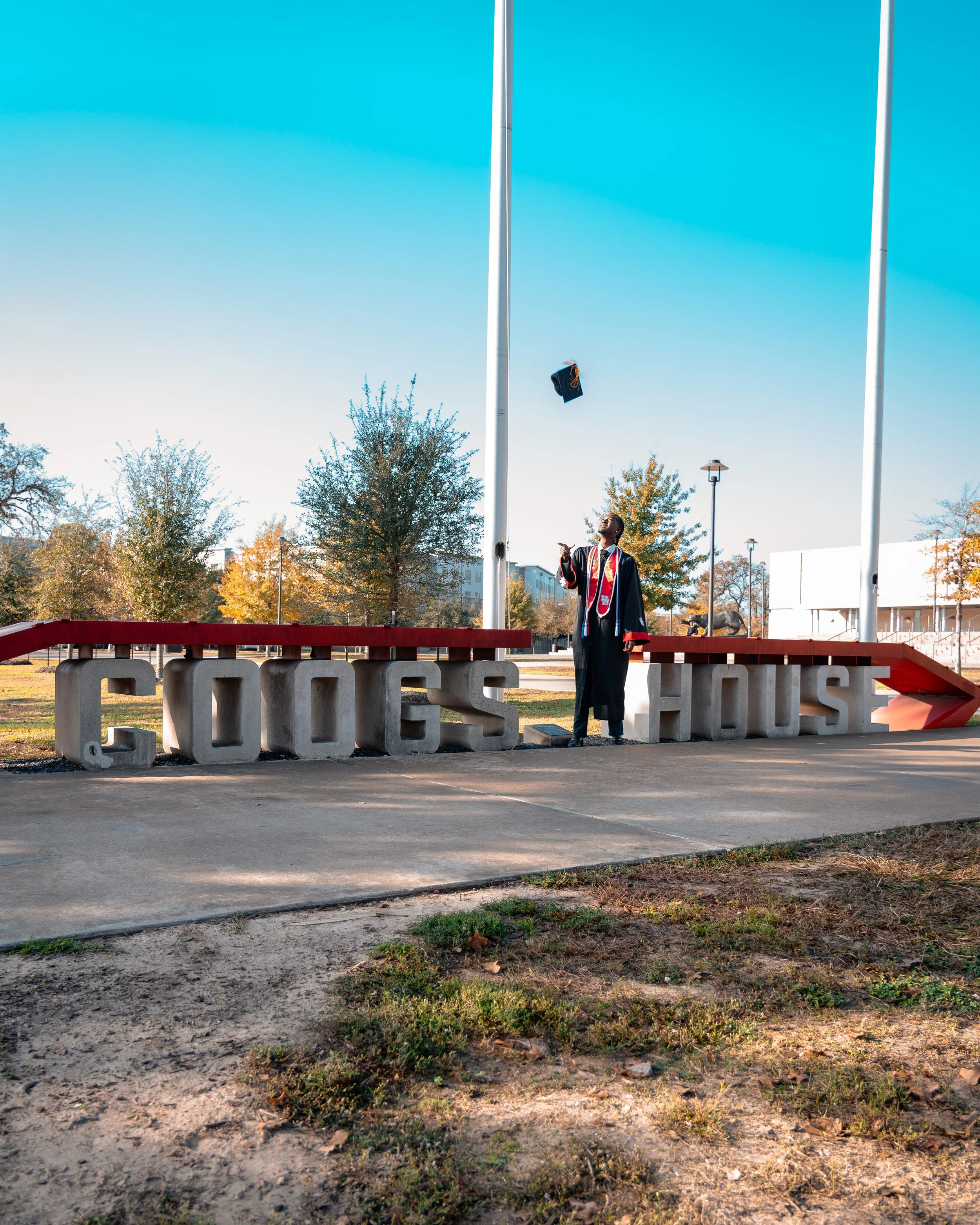 A graduation photoshoot with the graduate throwing up his cap in the air