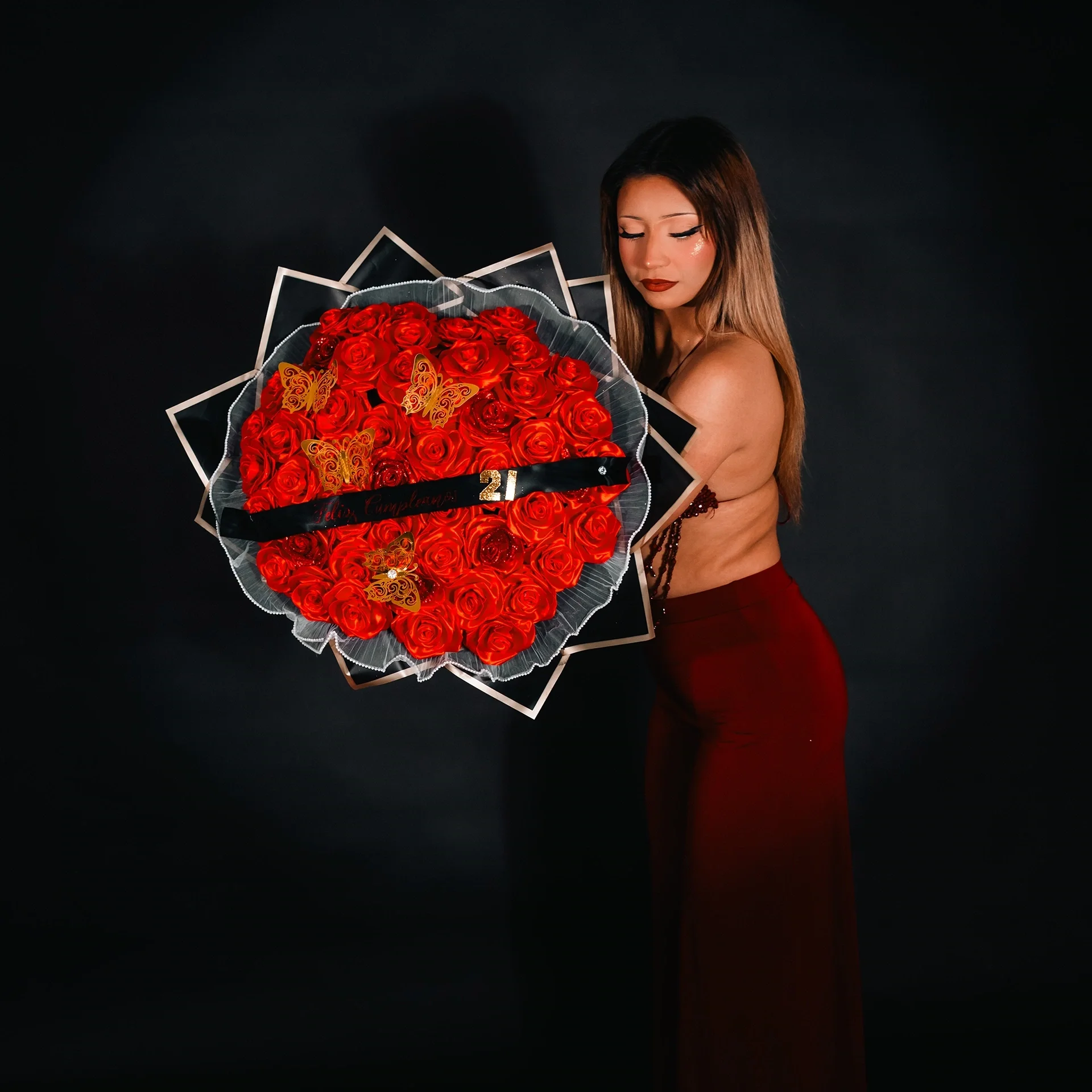 21st birthday photoshoot in Houston with Black and Red theme. Birthday girl holding red roses in a red dress.