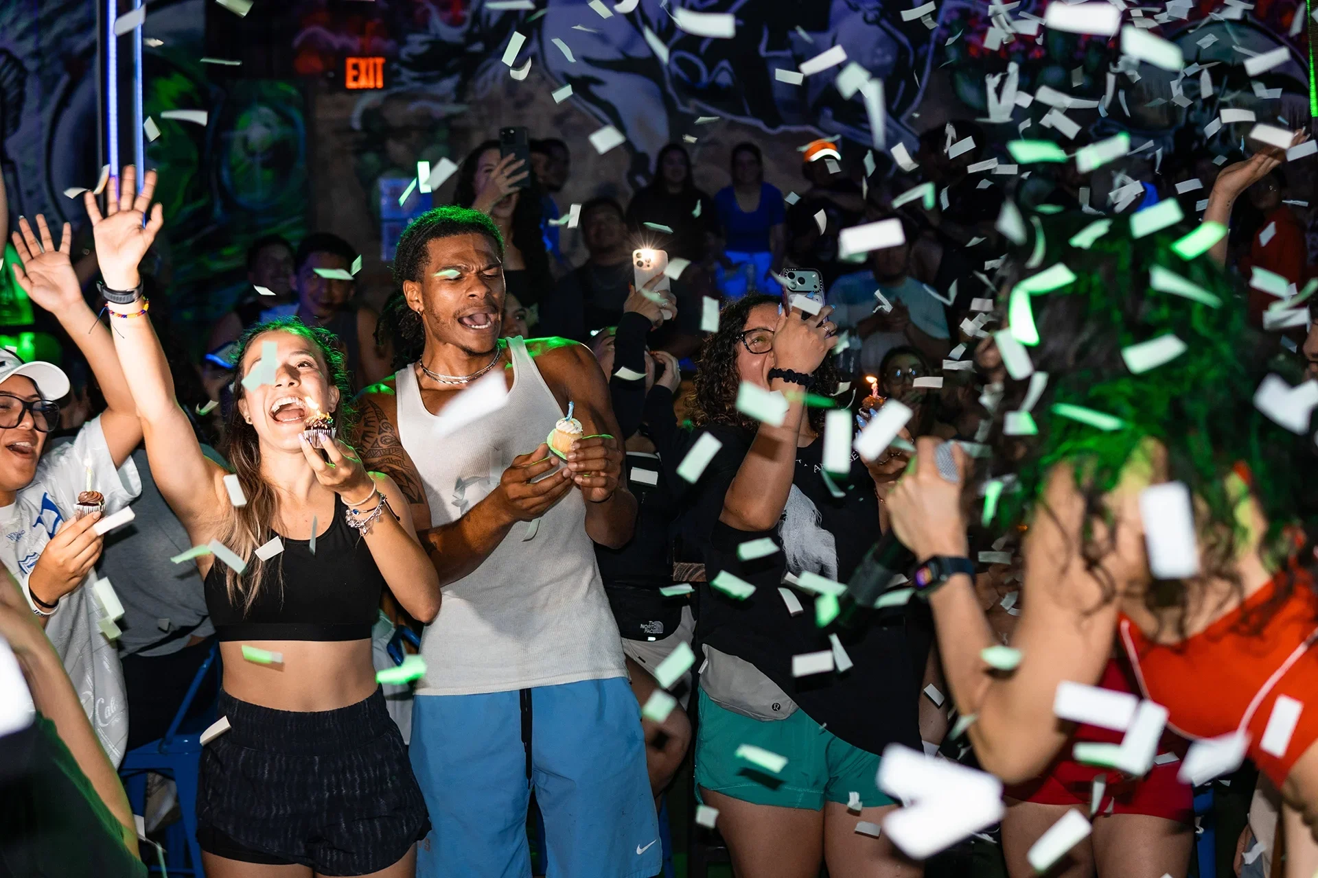 A group of people at Fuegos Nightclub in Houston celebrating as an event photographer photographs them.