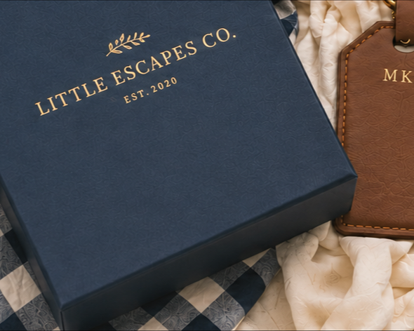 Little Escapes Co. gift box with a personalized leather luggage tag