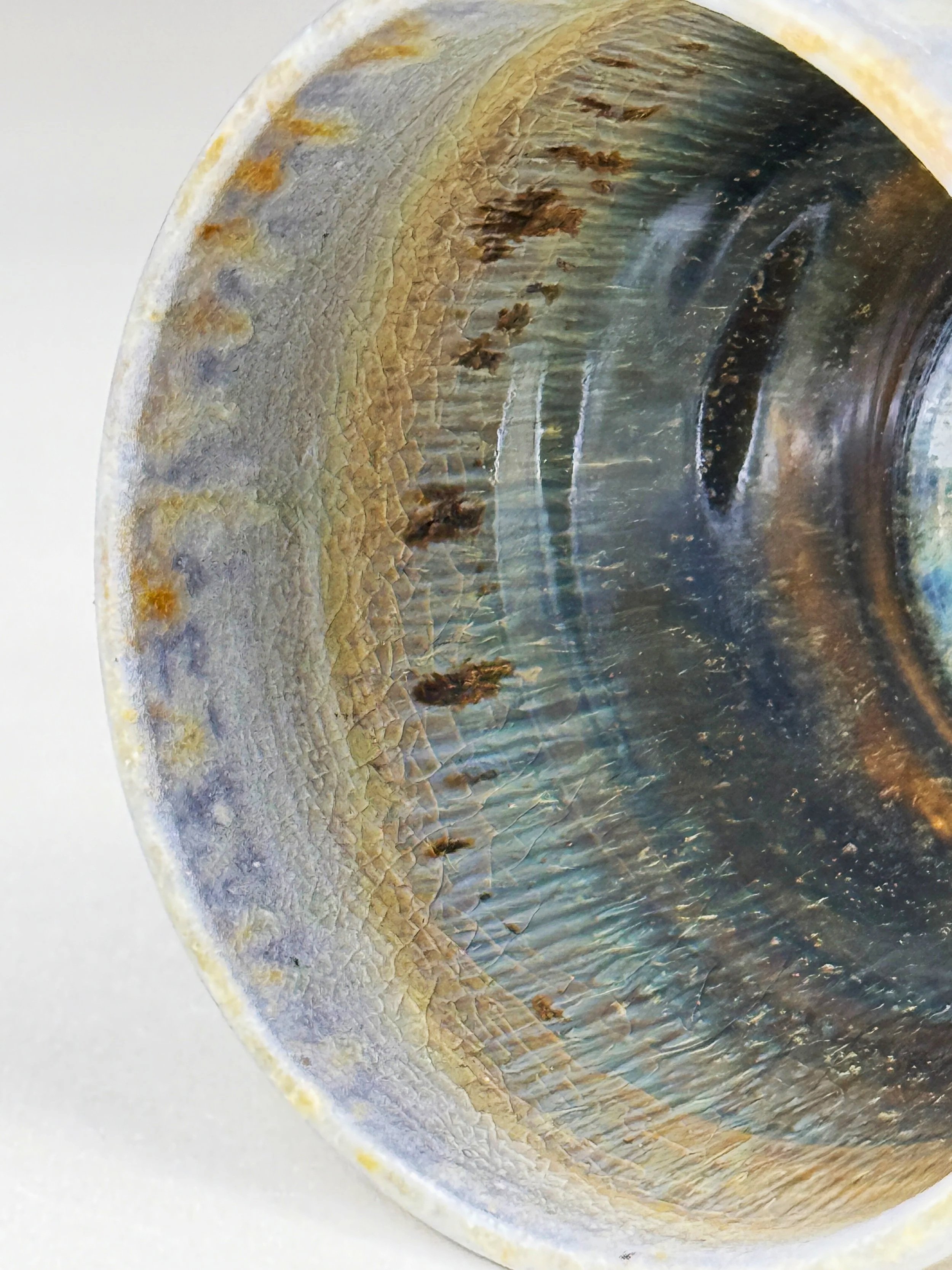 Close-up of the inside of a worn, rusty metallic pipe with peeling paint and corrosion.