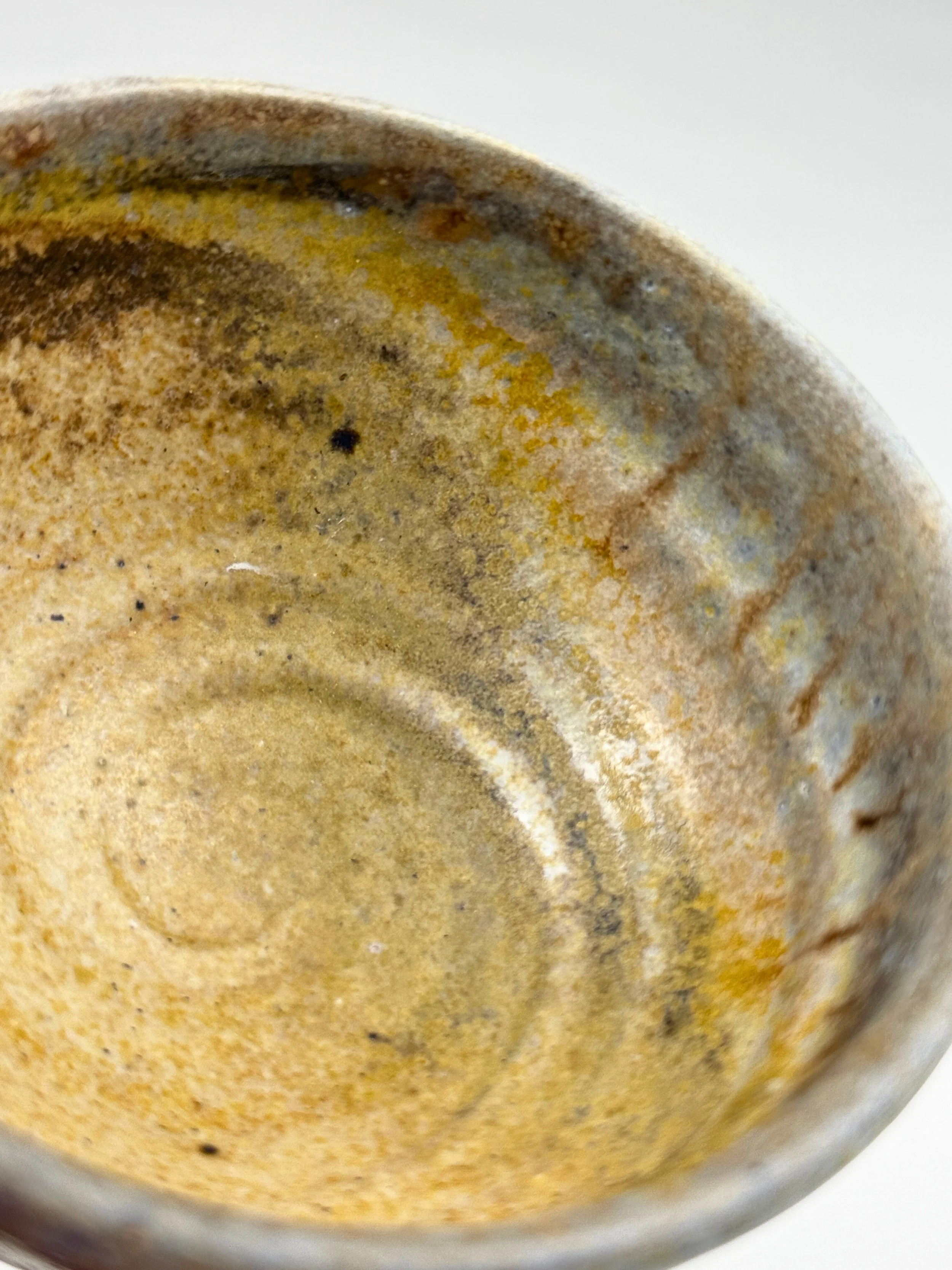 Close-up of the inside of a rusty, used coffee mug with coffee stains and residue.