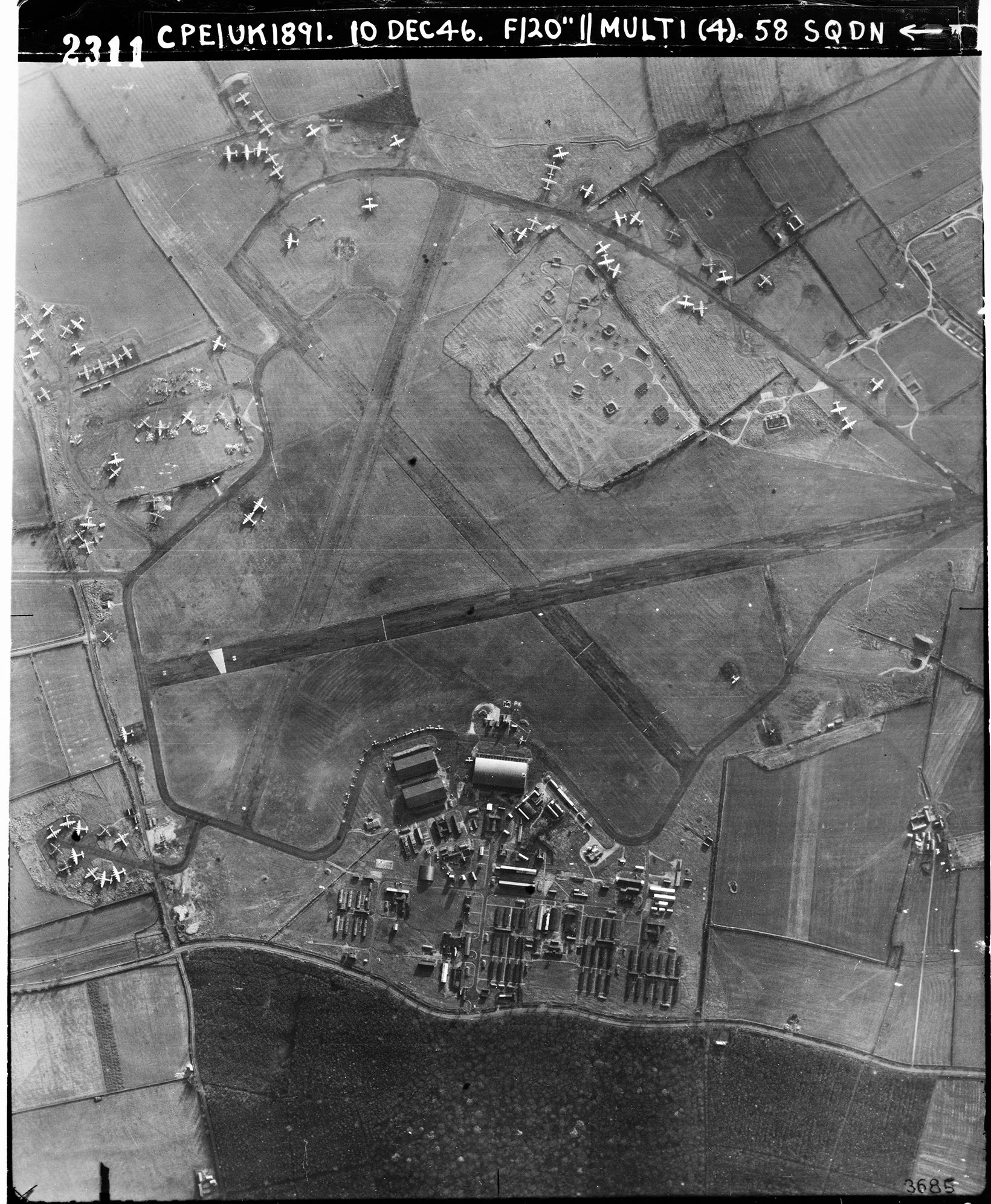 Black and white aerial photograph of an airfield with numerous parked airplanes, hangars, and surrounding fields and roads, dated December 10, 1946.