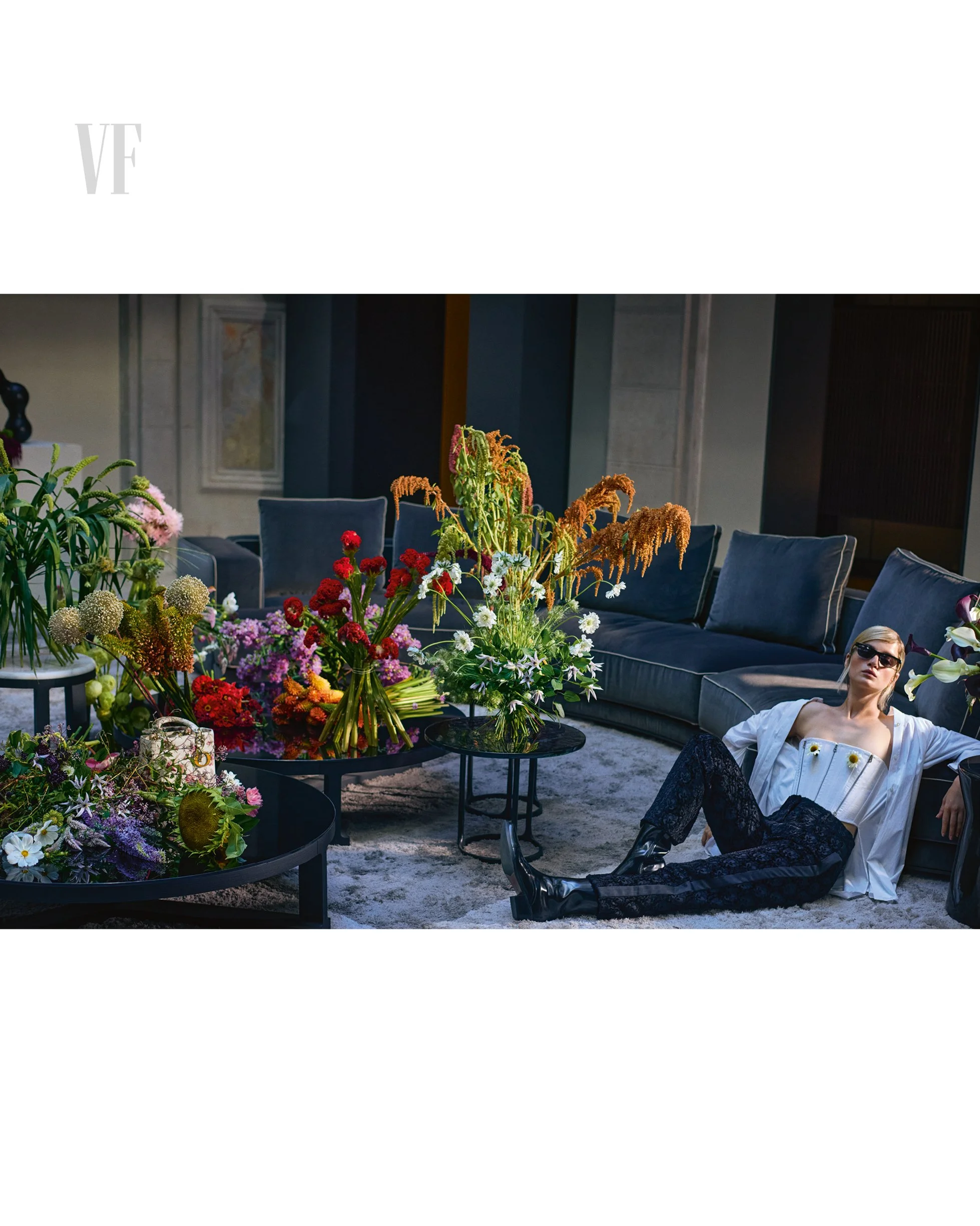 Vaso bianco con fiori di pesco rosa e orchidee viola, con borse e accessori da moda in studio di negozio