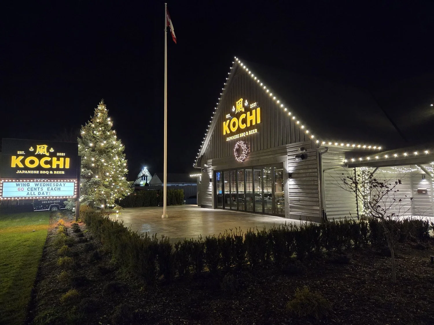 Complete Kochi storefront Christmas lighting with roofline, pillar wraps, tree wrap, and walkway lights in Niagara Falls.
