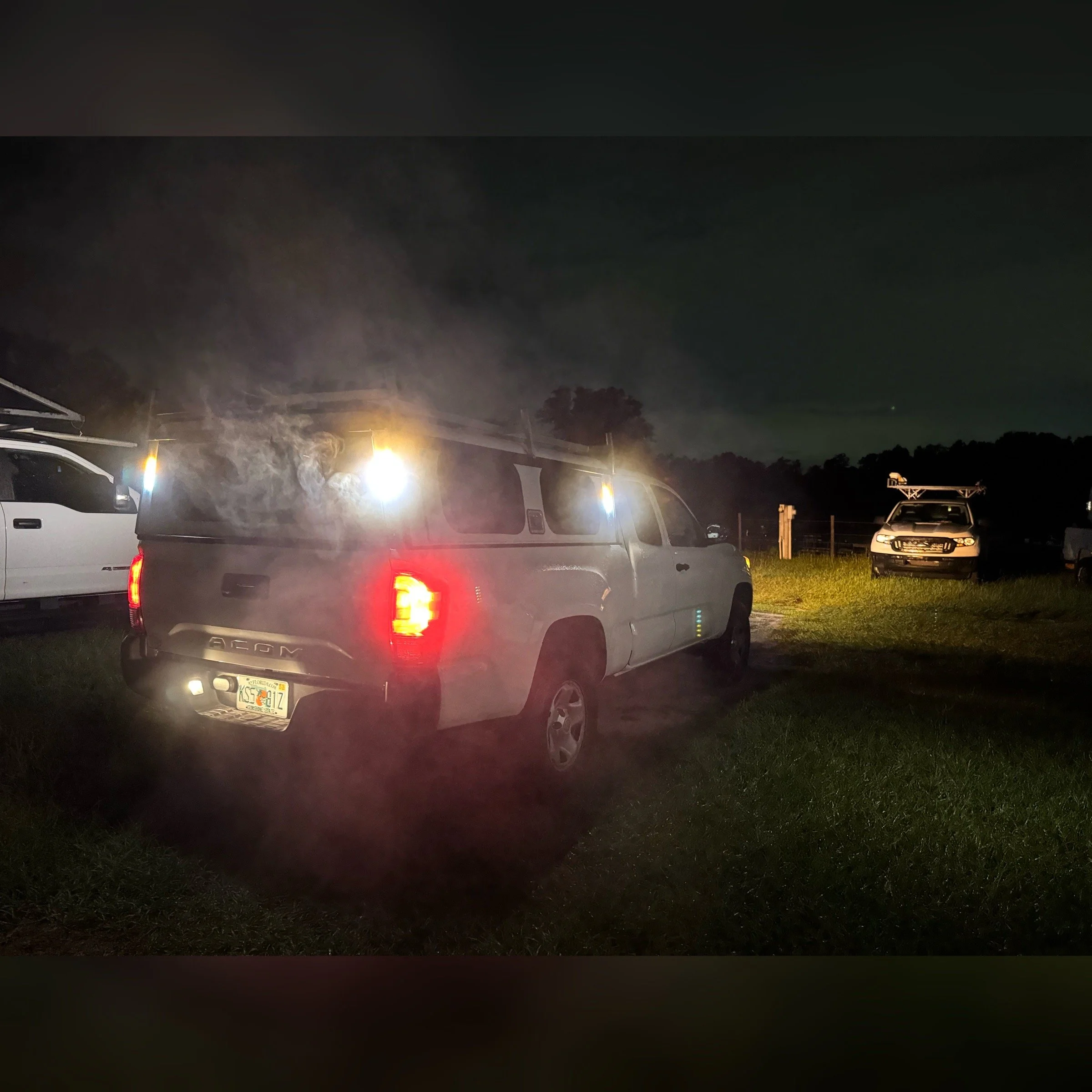 Close-up of the side of a fire truck with yellow and red reflective stripes, emergency lights, and a partially visible American flag.