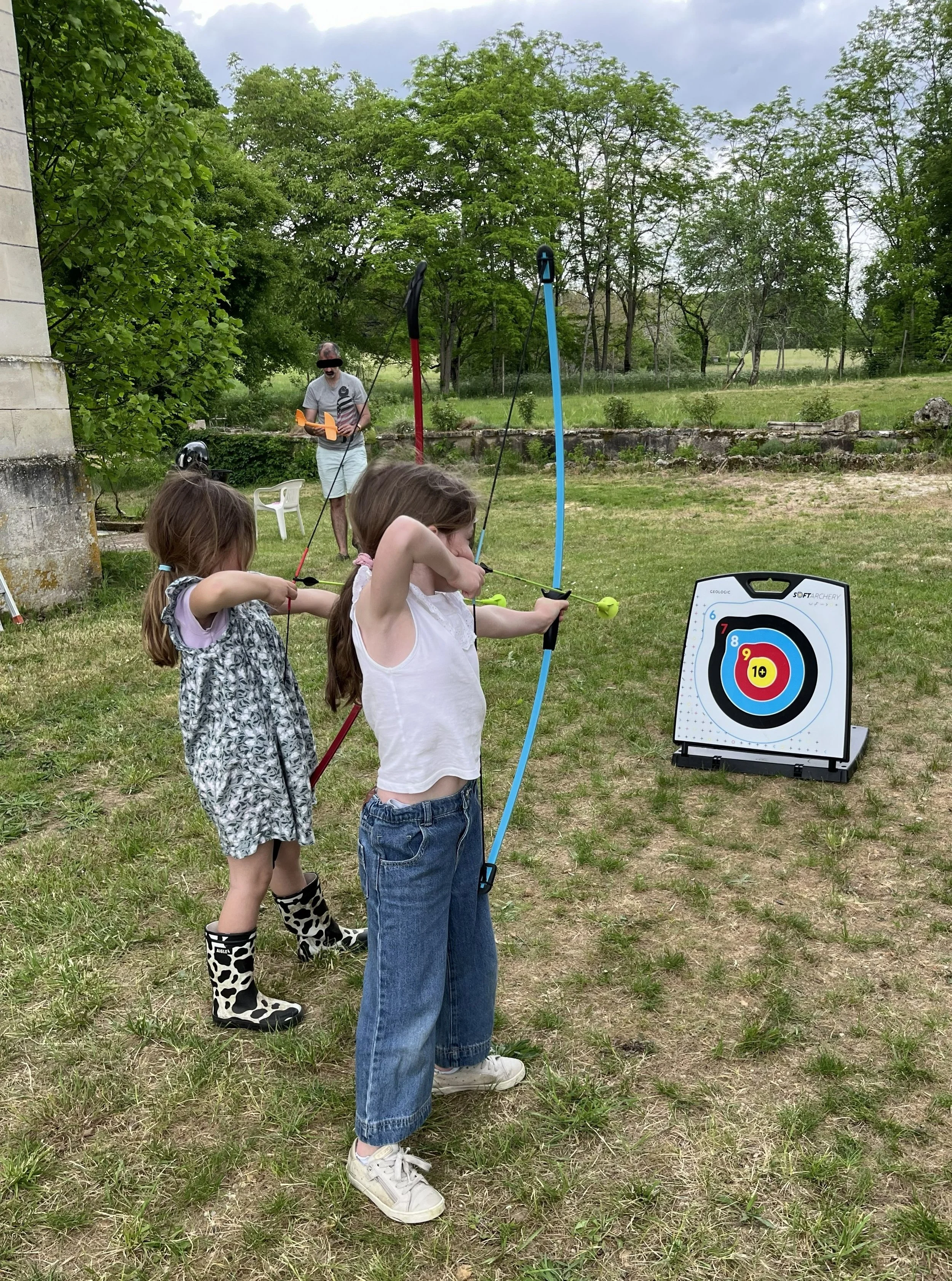 enfants jouant au tir à l'arc dans le jardin