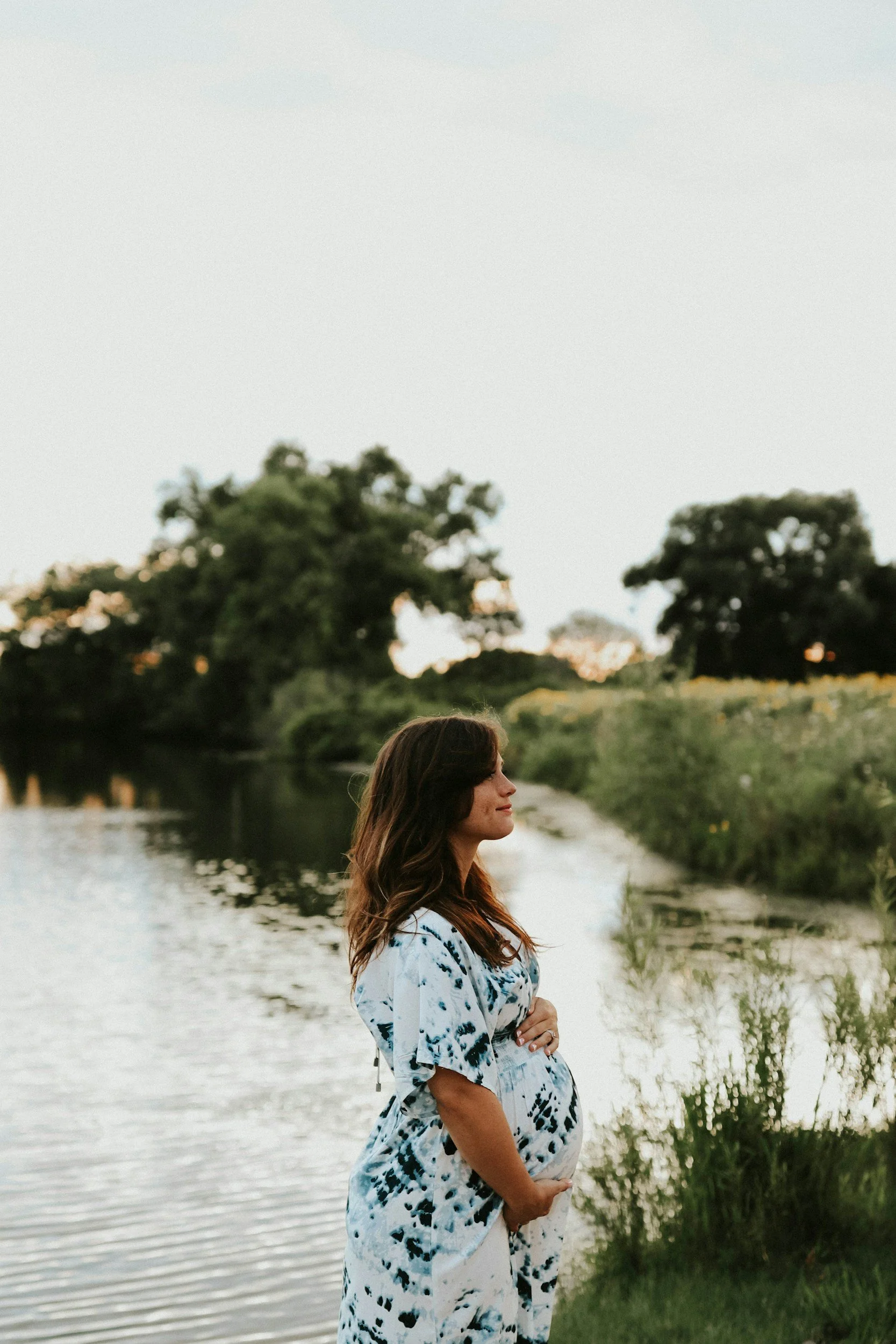 Pregnant woman standing by the water, representing Motherwell's Bump to Baby prenatal support circle in Austin and Cedar Park, TX