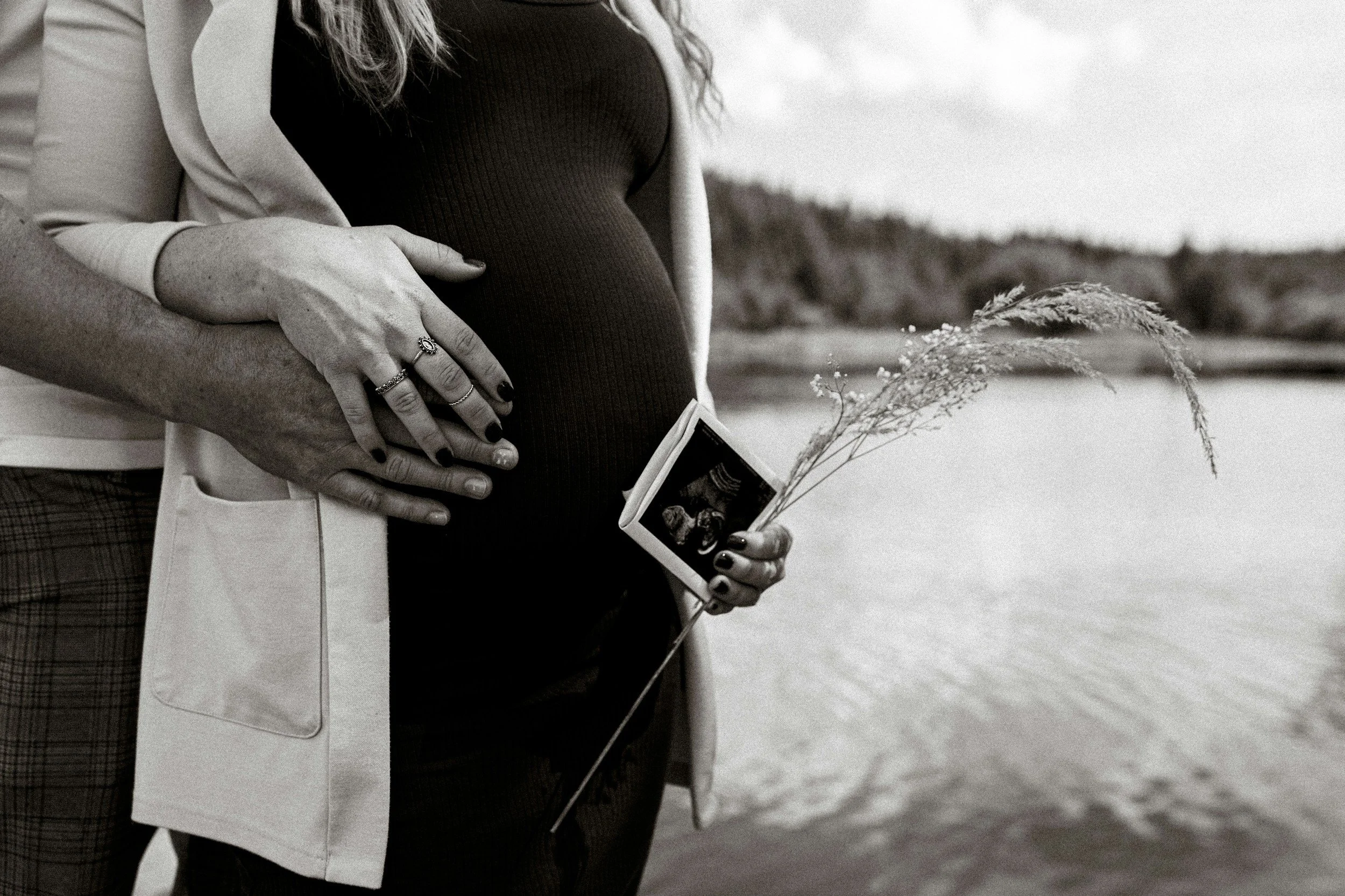 Black and white photo of a pregnant belly holding an ultrasound image, representing Motherwell's Bump to Baby circle
