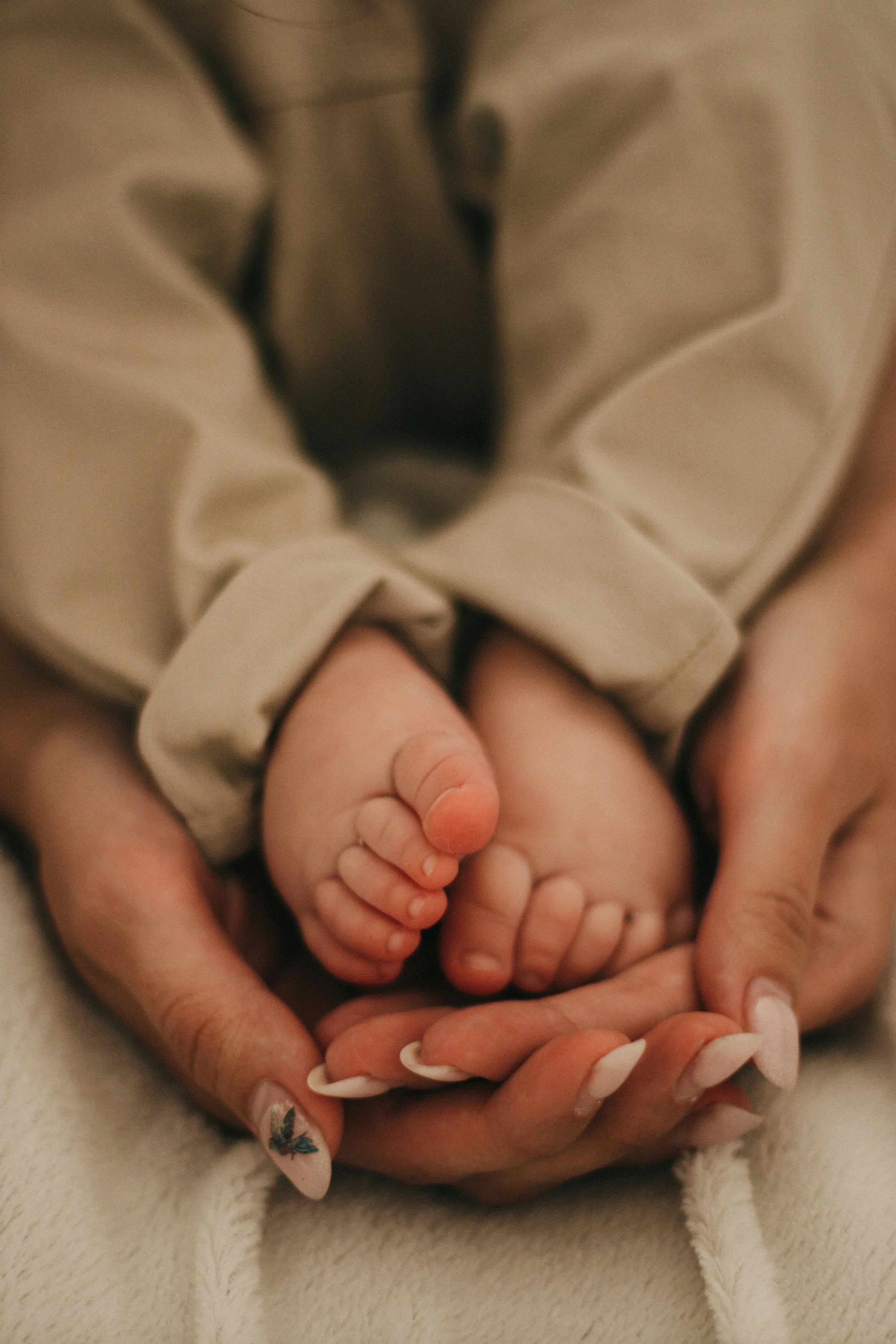 Newborn baby's feet cradled in a parent's hands, representing Motherwell's birth support services in Austin and Cedar Park, TX