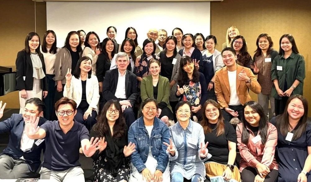 Group of diverse people smiling and posing for a photo in a conference room.