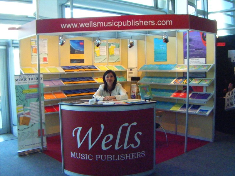 Booth for Wells Music Publishers at a trade show, displaying music books and promotional materials.