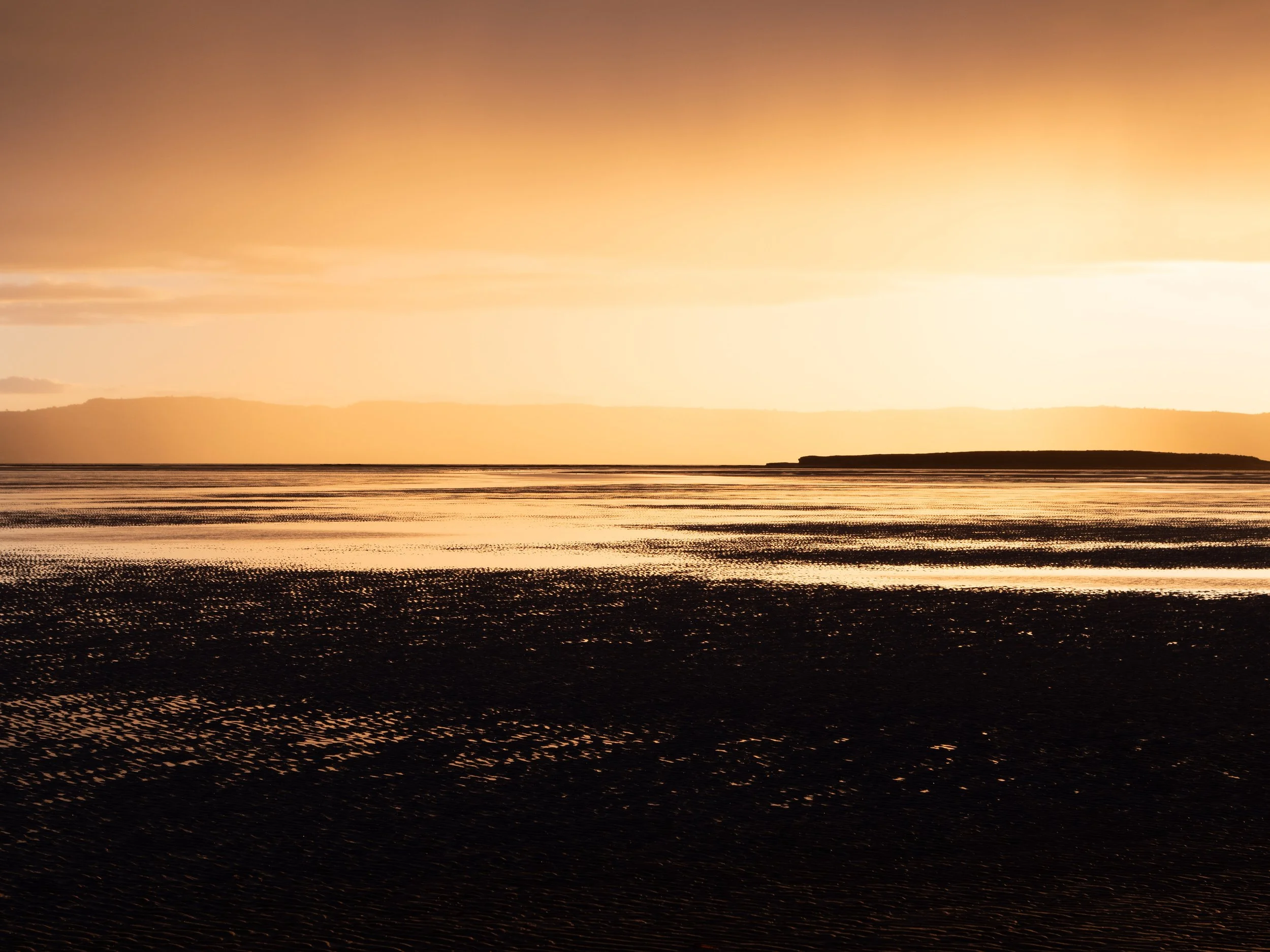 Late afternoon sun across mudflats