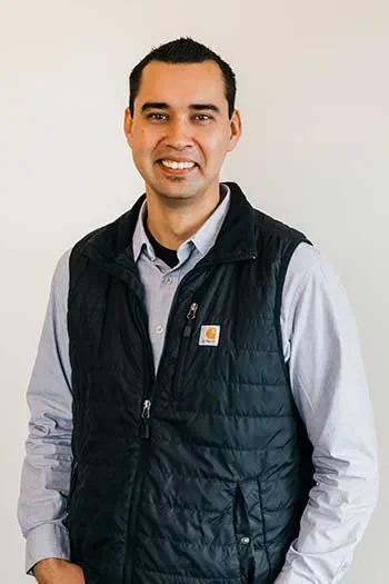 James Hogue of Edgell Building. A smiling man wearing a black vest over a light gray button-up shirt, standing against a plain white background.