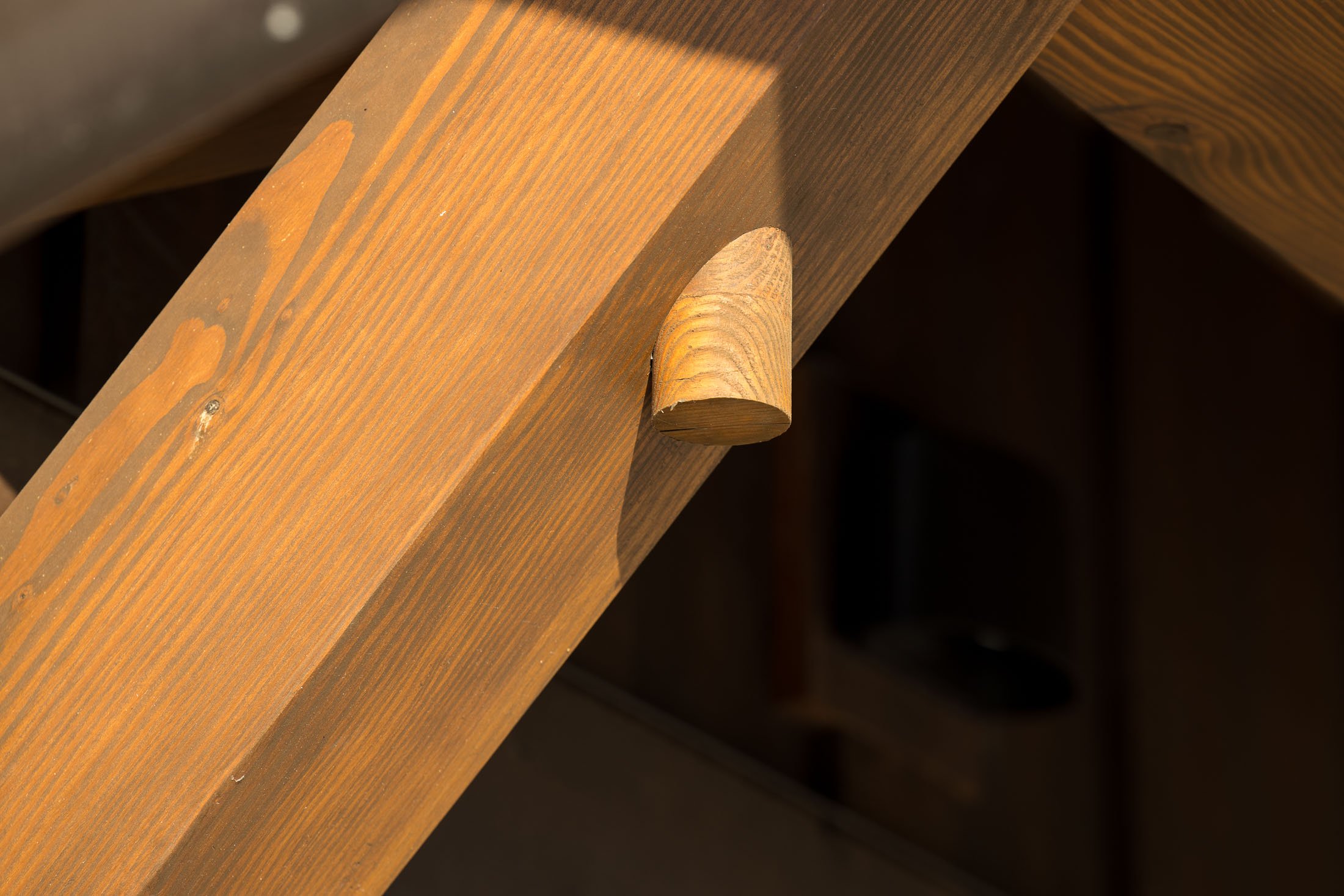 Close-up of a wooden stair stringer with a wooden support bracket underneath. Custom Home built in Montana by Edgell Building.