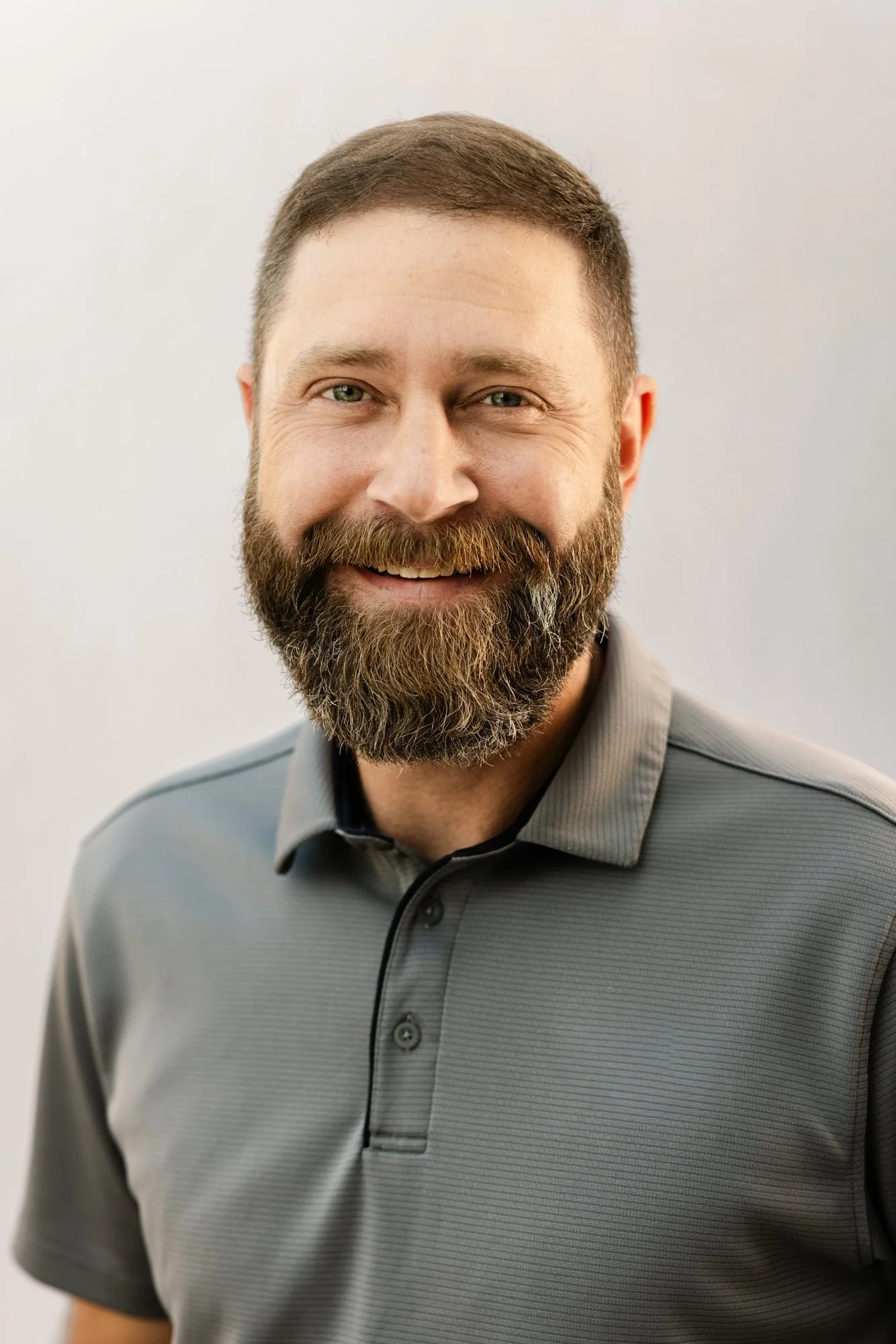 Zack Waggener of Edgell Building. A smiling man with short brown hair and a full beard, wearing a gray polo against a plain light background.