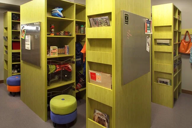 Green privacy booths with blackboards, shelves, and bulletin boards inside a classroom, with colorful stools nearby. Custom Home built in Montana by Edgell Building.