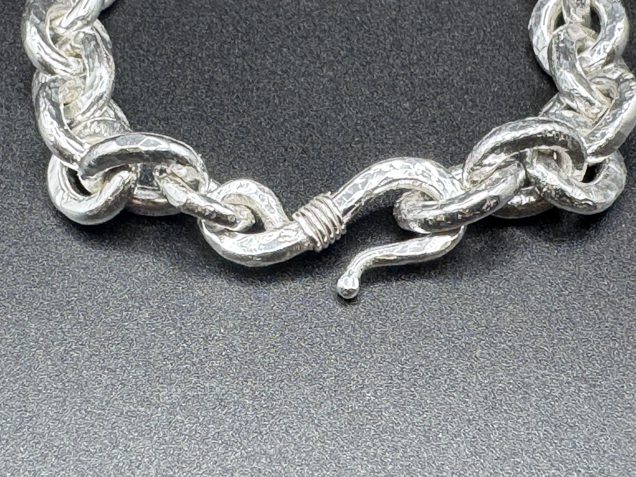detail:  man's bracelet, hand forged and textured heavy link sterling silver with J-hook clasp