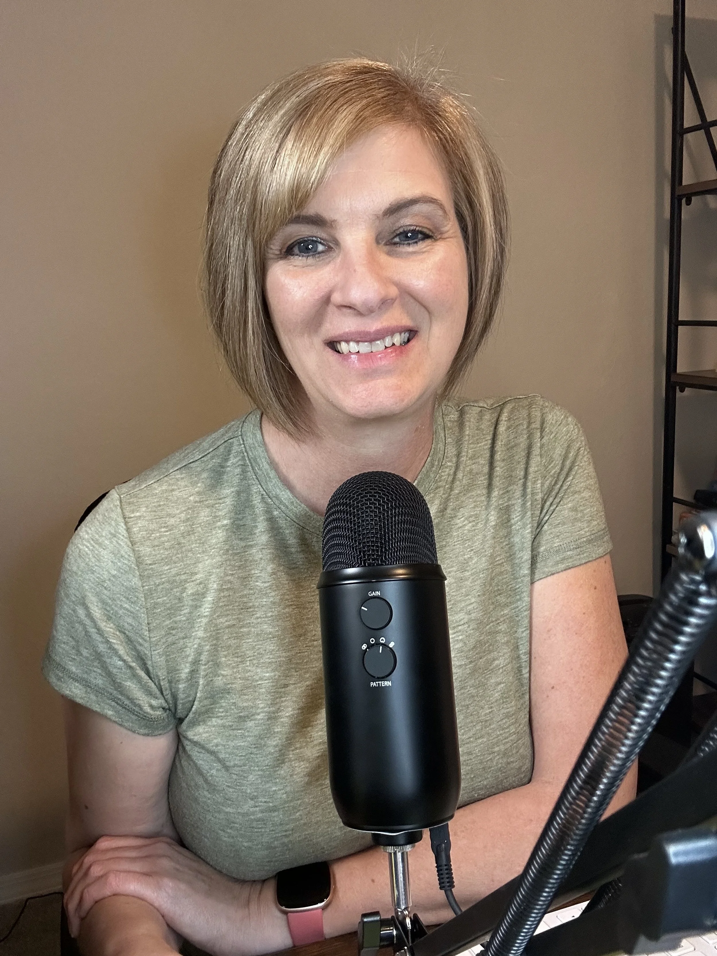 dalene higgins at her podcast mic in a green shirt