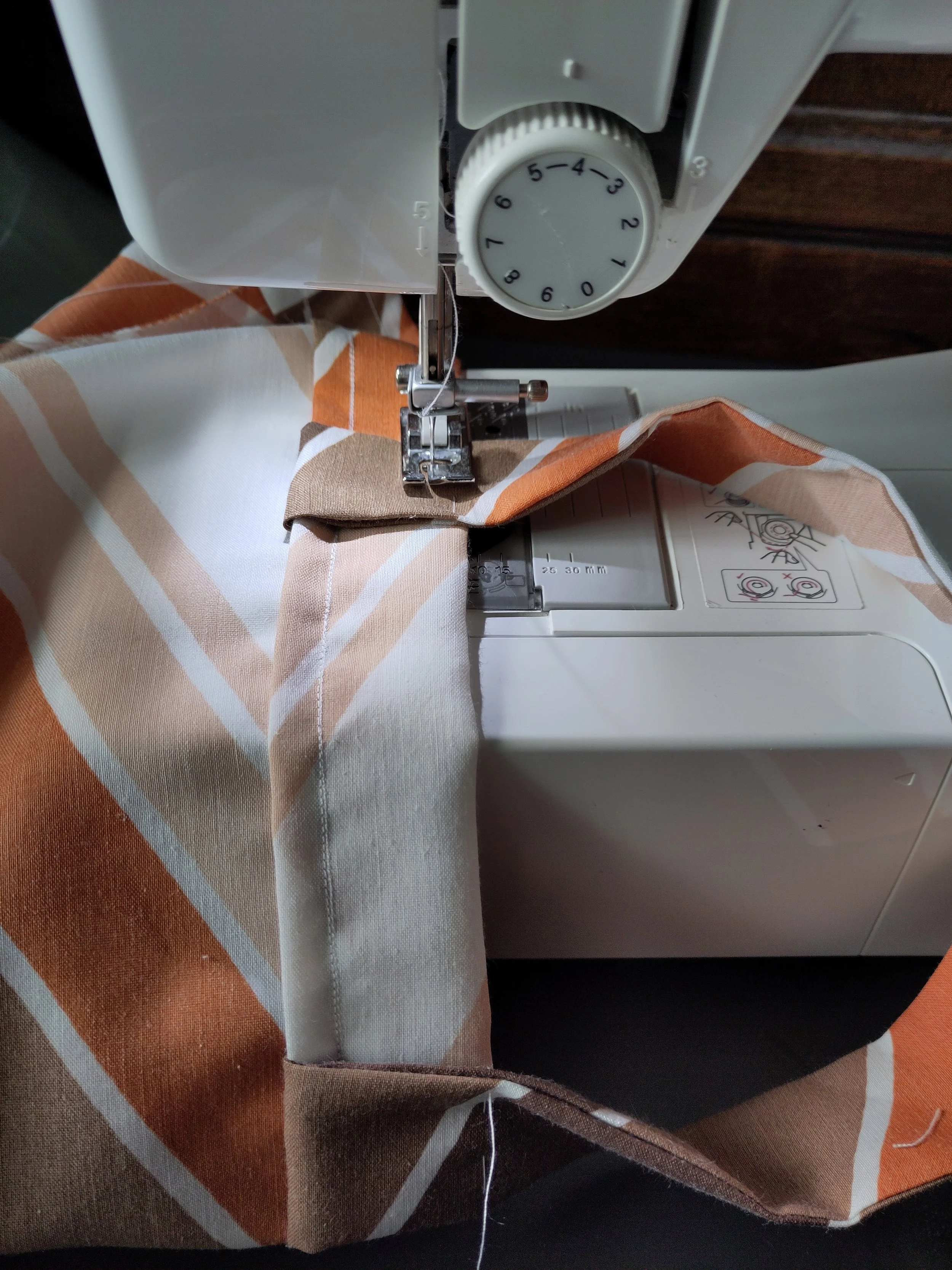Photo of fabric bag handles being sewn onto a reusable shopping bag using a sewing machine