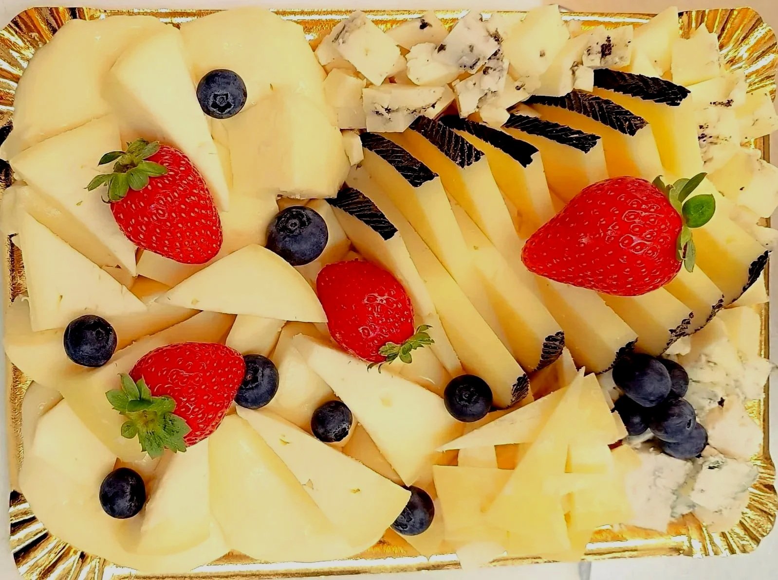 Plato con variedad de quesos, fresas y arándanos. Tabla de quesos, queixos Angel,  Quesos plaza de abastos Ourense. Quesería Galicia. Quesería Ourense