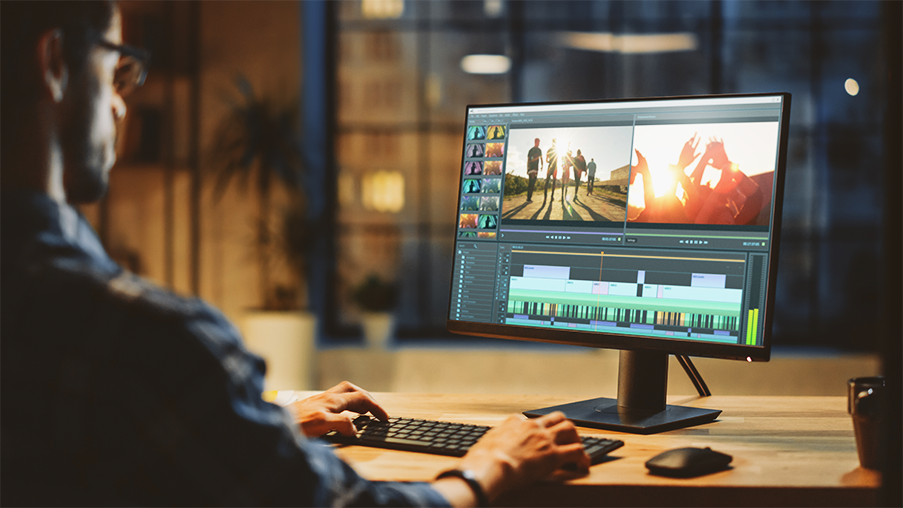 Video editor working on a professional project using modern editing software at a bright, natural-light workstation; a OC Videography post-production environment emphasizing detail and color accuracy.
