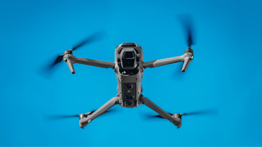4K camera drone with four propellers flying against a blue sky representing OC Videography’s aerial filming, drone cinematography, and real-estate video services in Southern California.