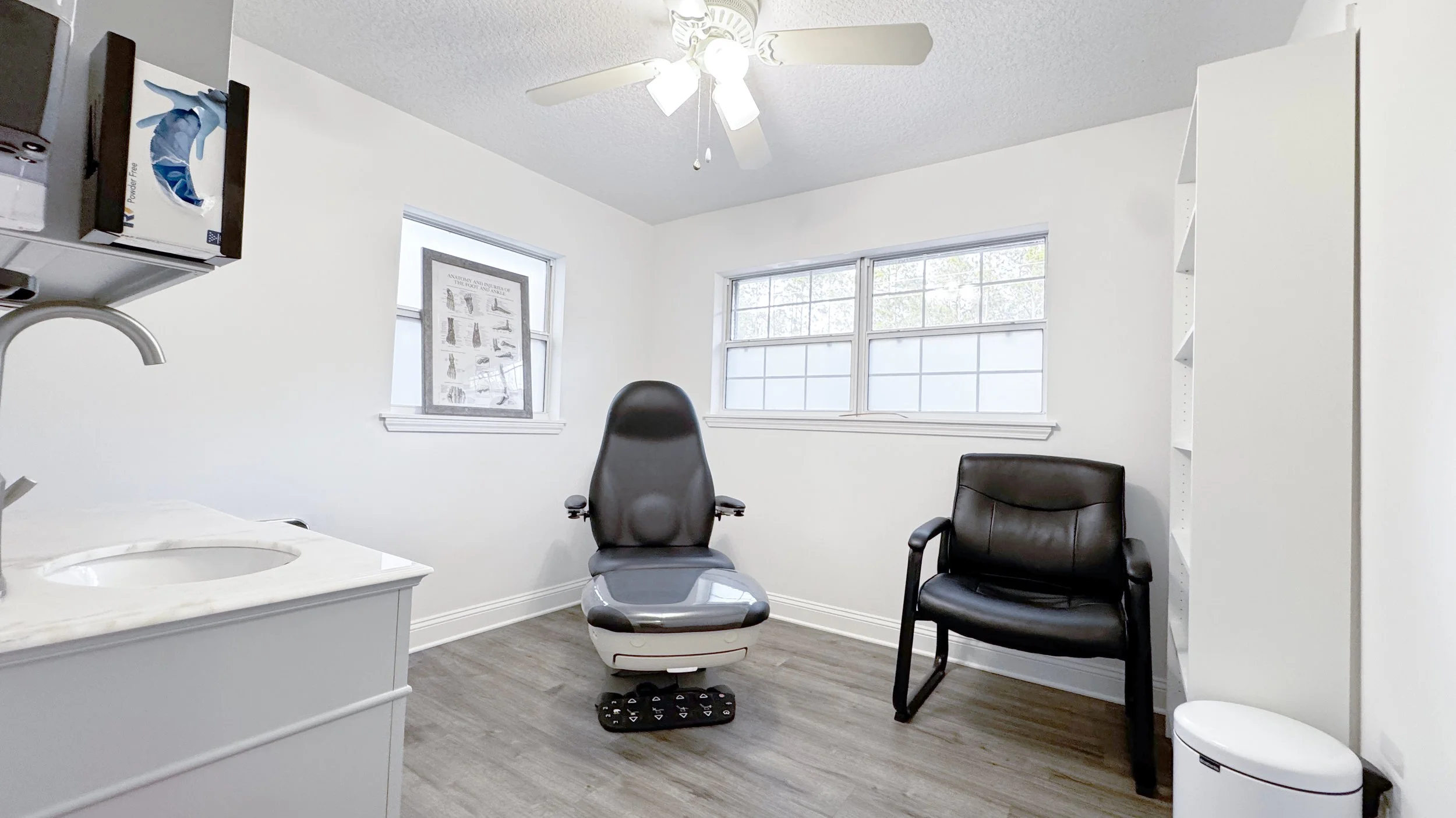 Photo of the doctor's room containing a reclining patient chair and seat