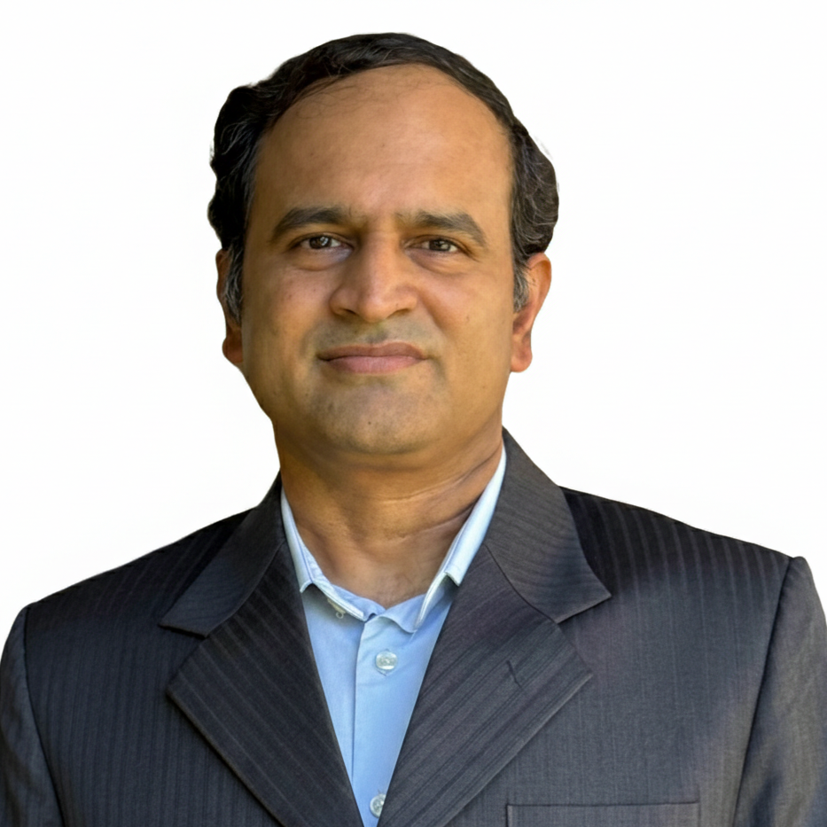 A professional man with dark hair, wearing a black pinstripe suit and light blue shirt, standing against a plain white background.