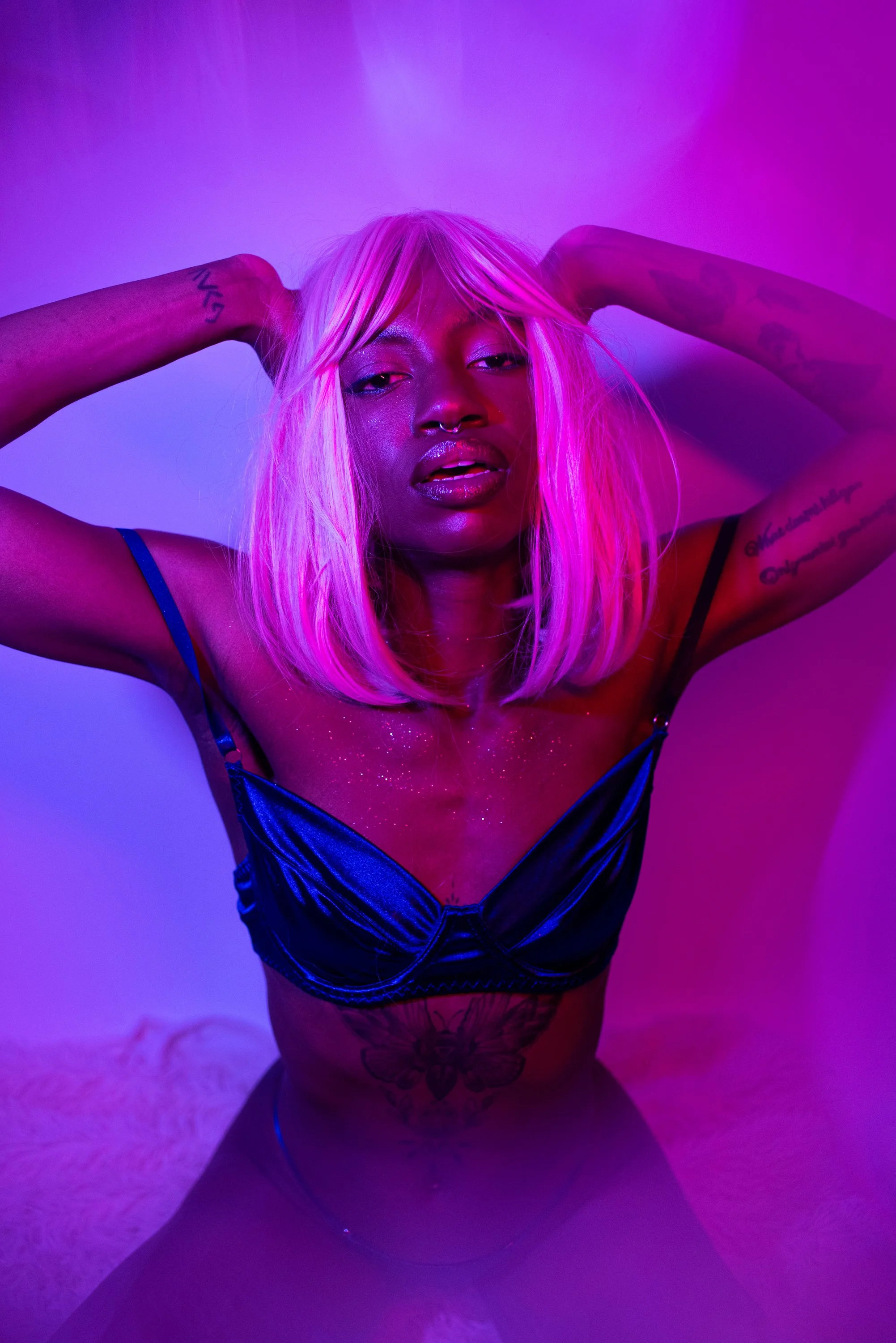 Pink neon session with Djau, showcasing bold lighting and elegant pose.
