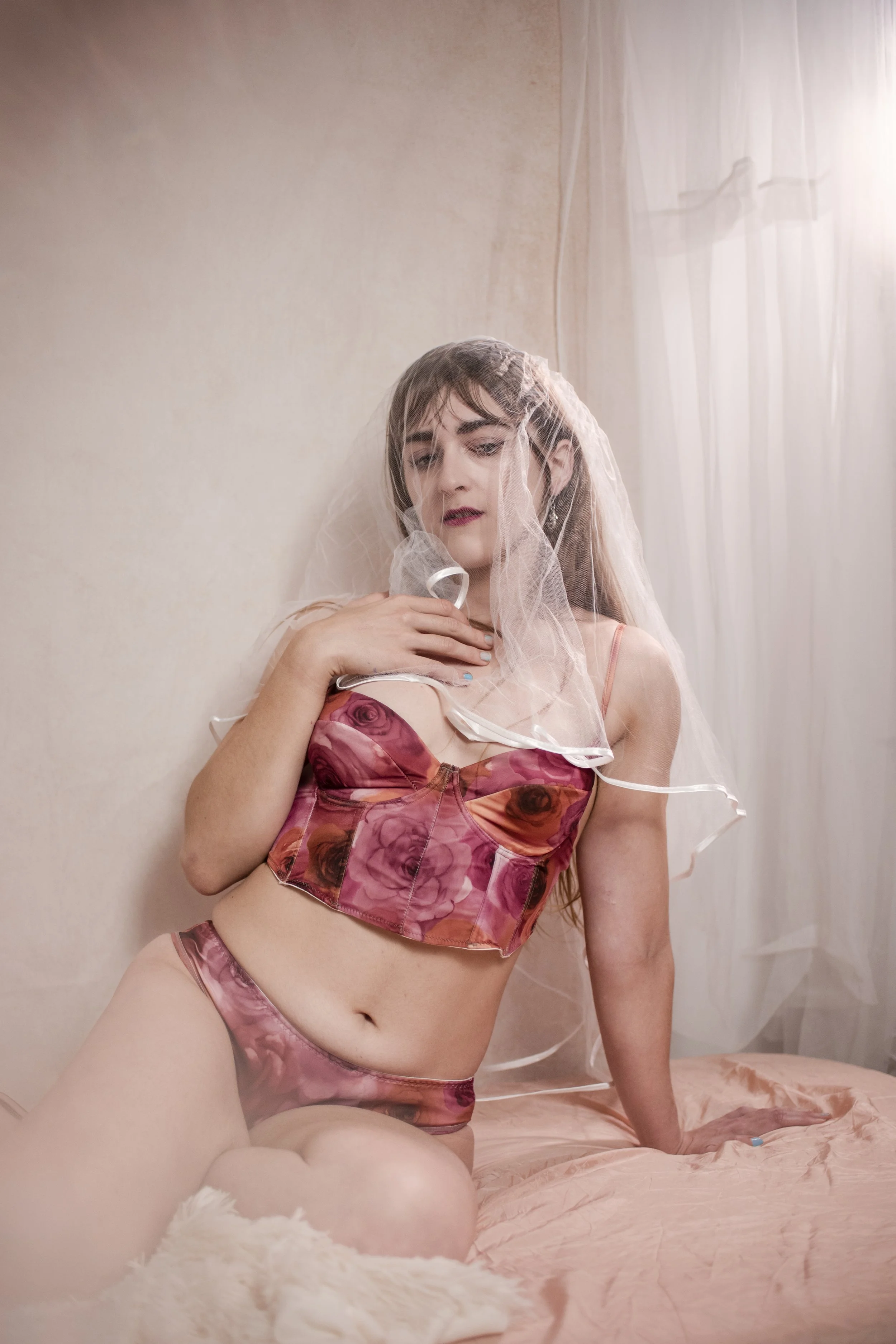 blonde woman with pink lingerie and a bridal veil